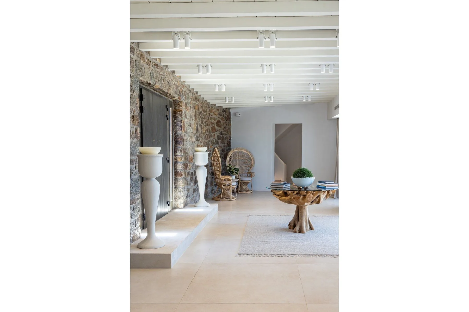 A bright living room features a stone wall and a low table beside the seating area.