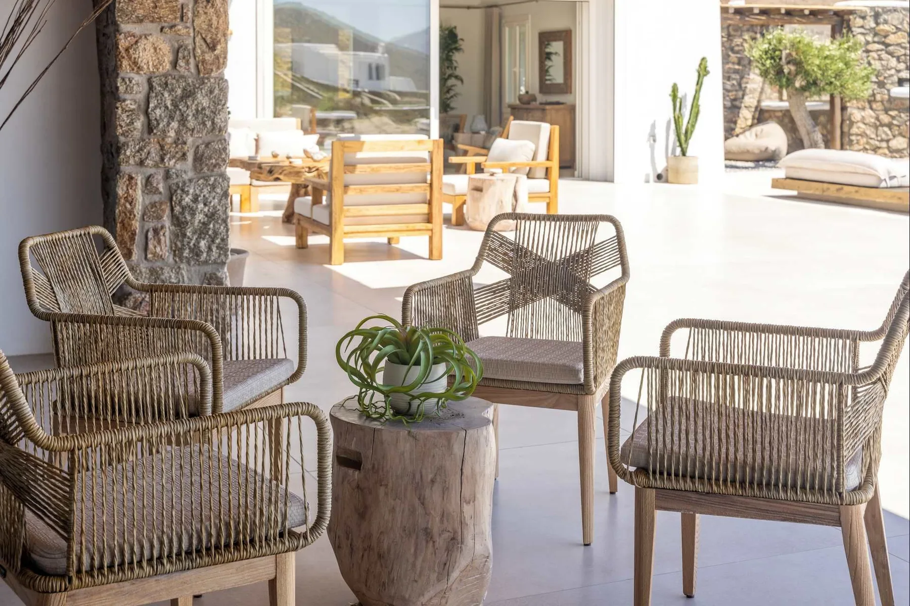 A bright patio seating area with woven chairs and a low table.