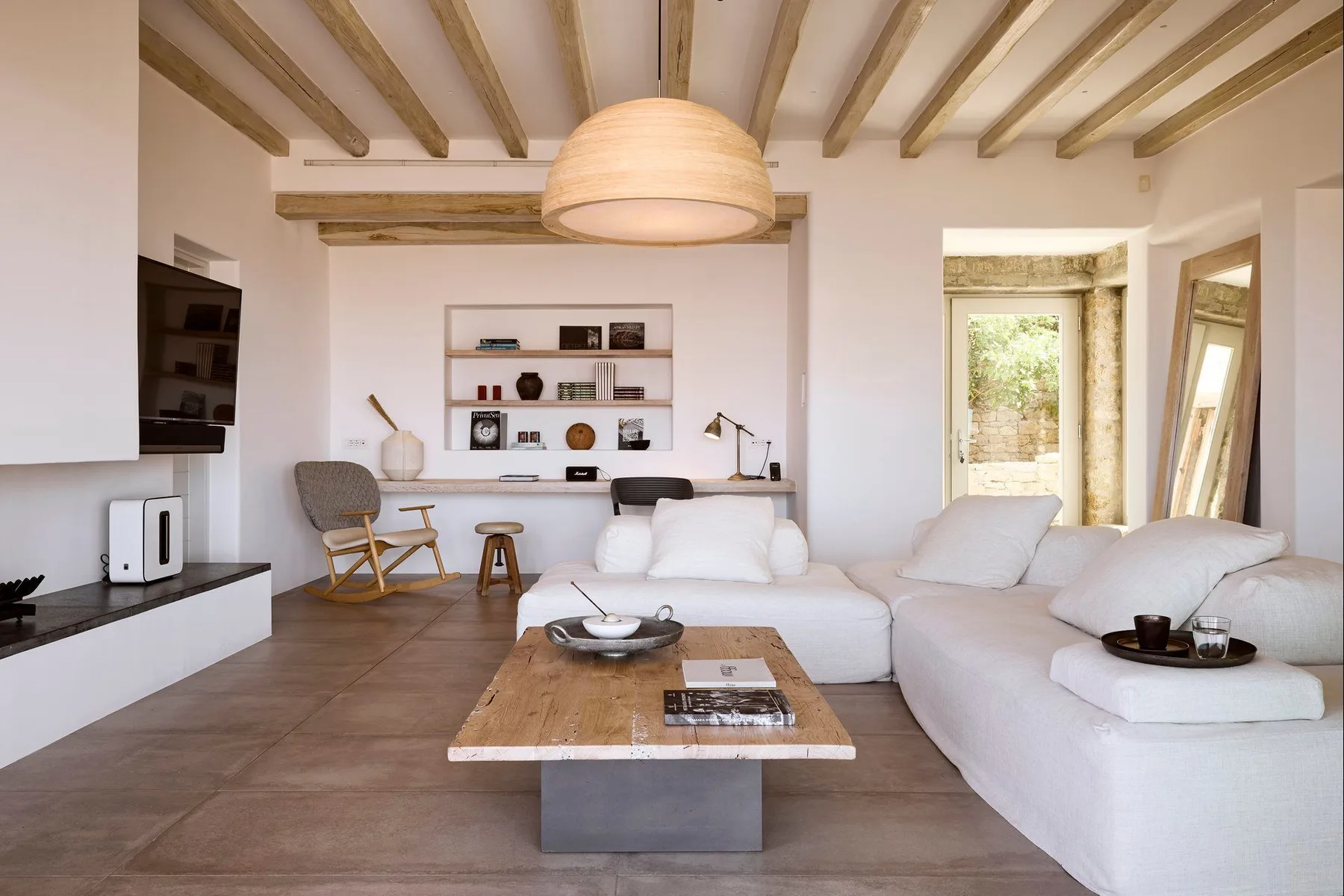 Una sala luminosa con una zona de asientos seccionales y una mesa de centro de madera.