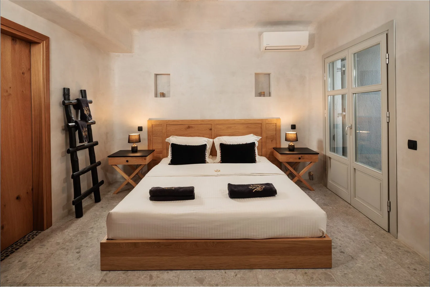 A bedroom with a double bed, wooden headboard, and bedside tables.