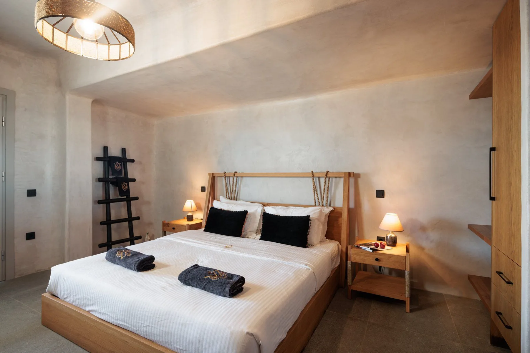 A bedroom with a bed, bedside tables, and a ceiling light.