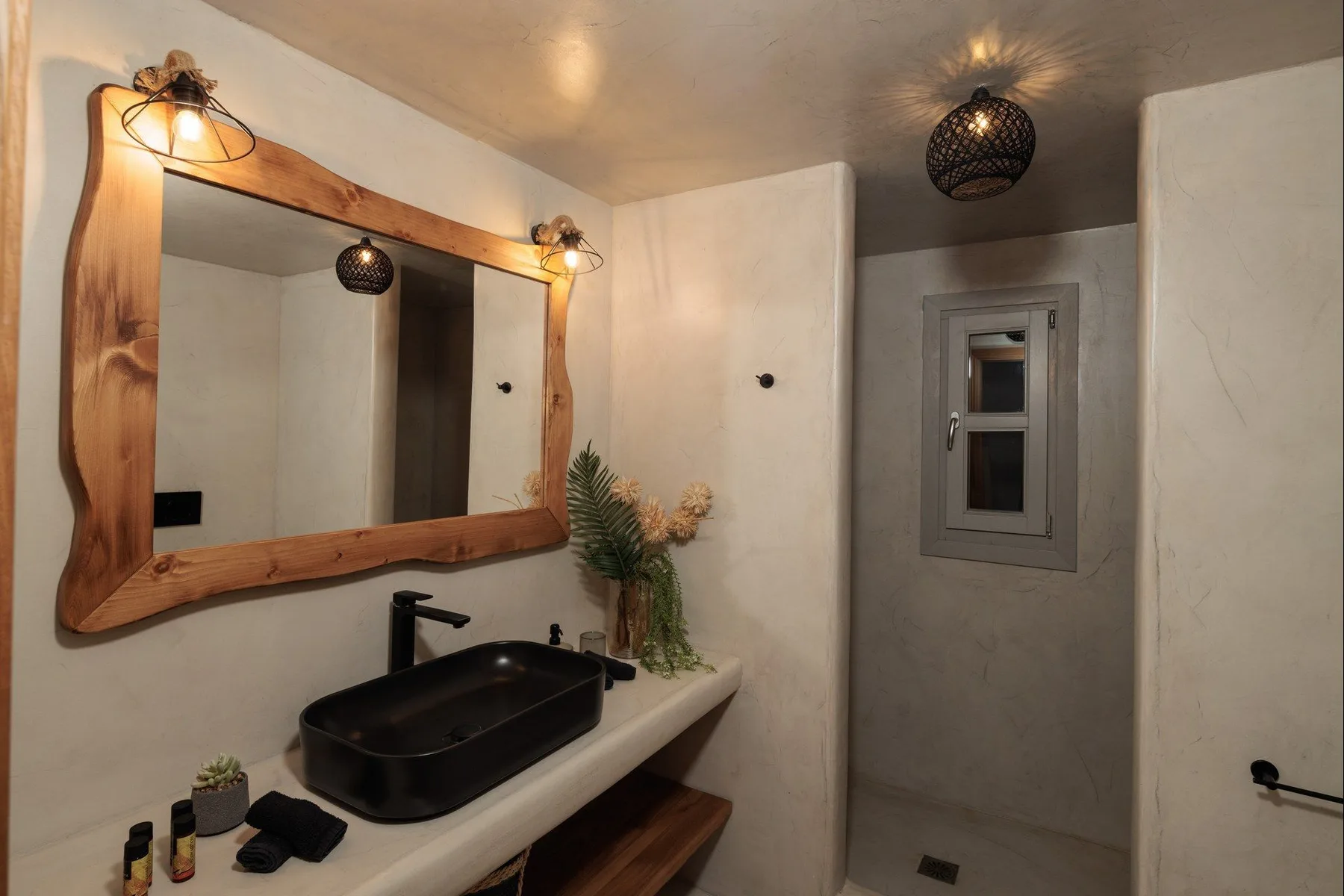A bathroom vanity with a vessel sink and a large framed mirror.