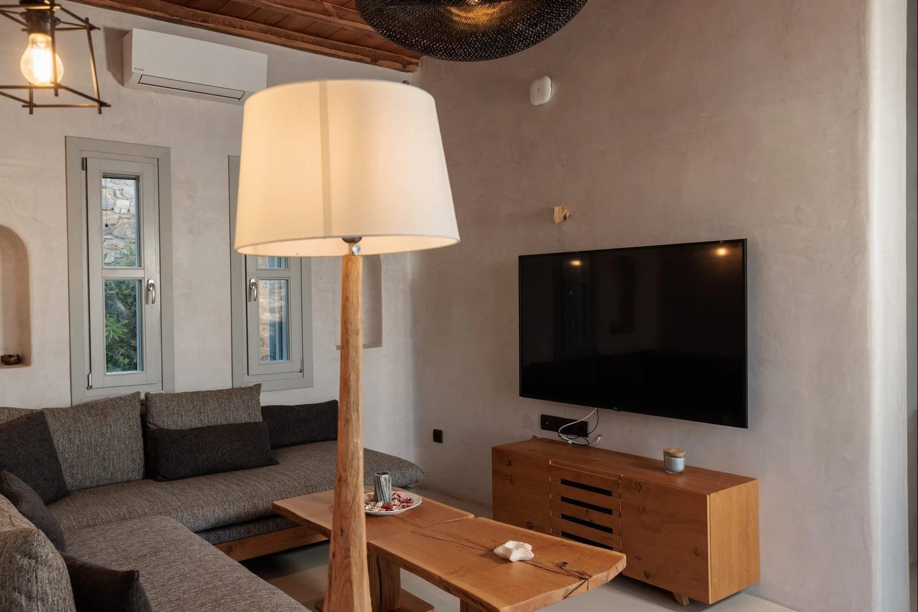 A living room with a sectional seating area, coffee table, and wall-mounted television.