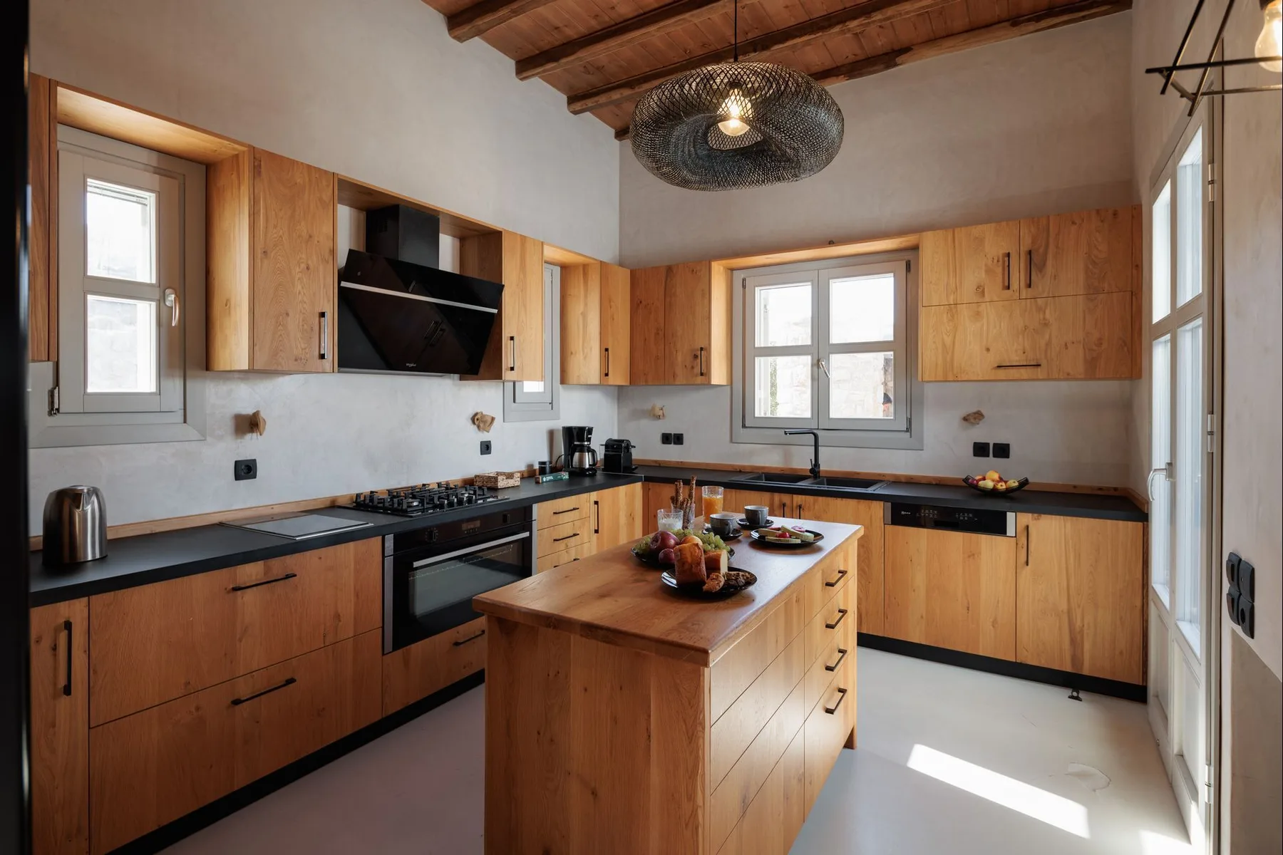 A kitchen with wooden cabinets, dark countertops, and a central island.