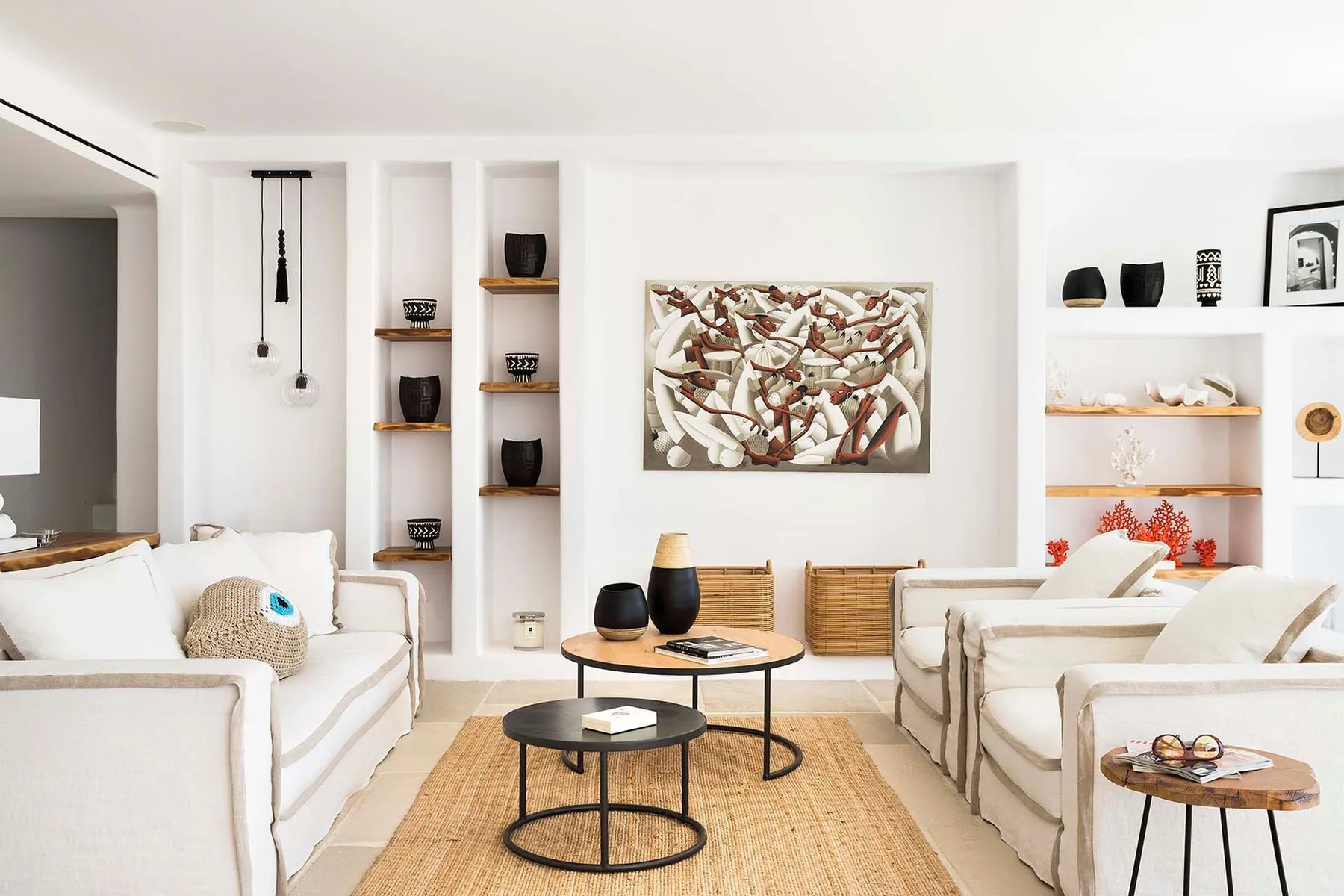 A bright living room with light seating, a central coffee table, and wall art.