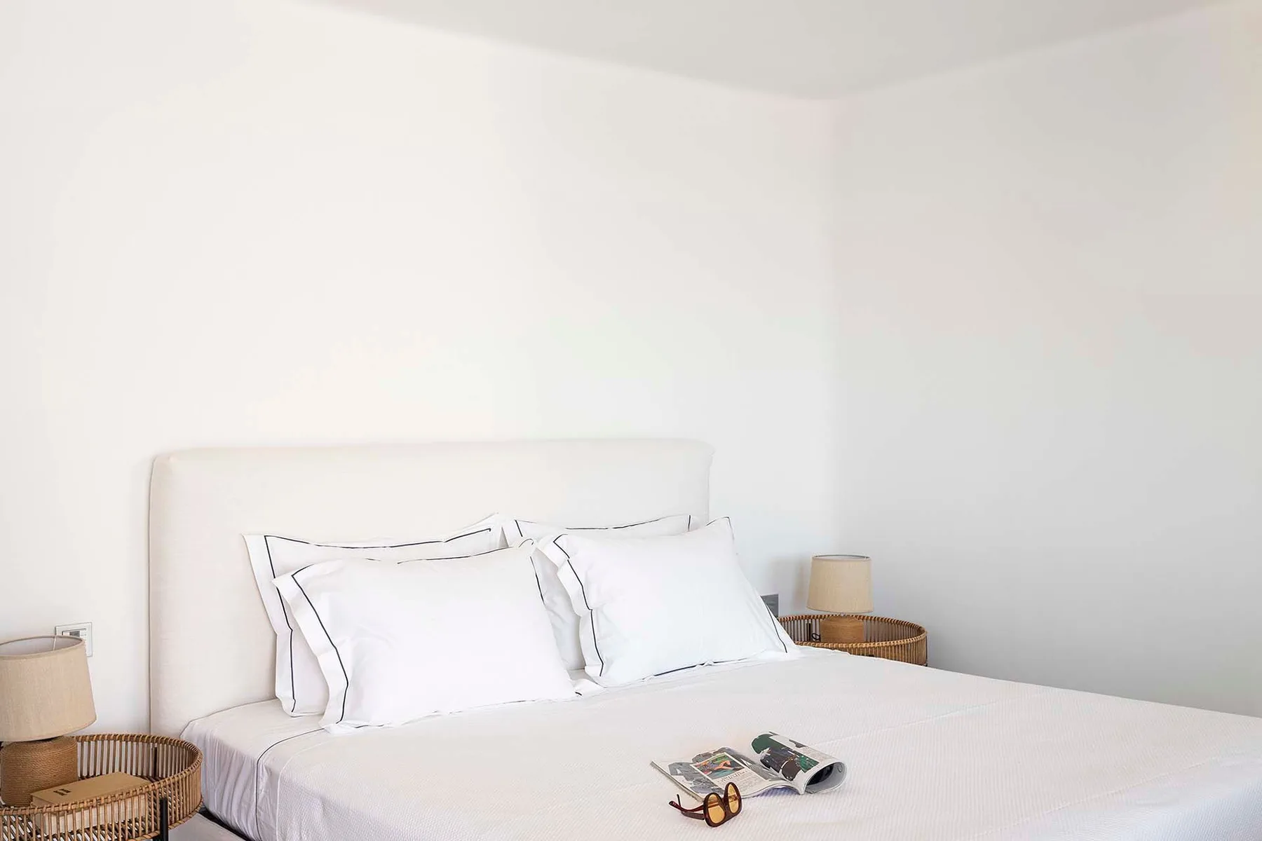 A bedroom with a neatly made bed and two pillows.