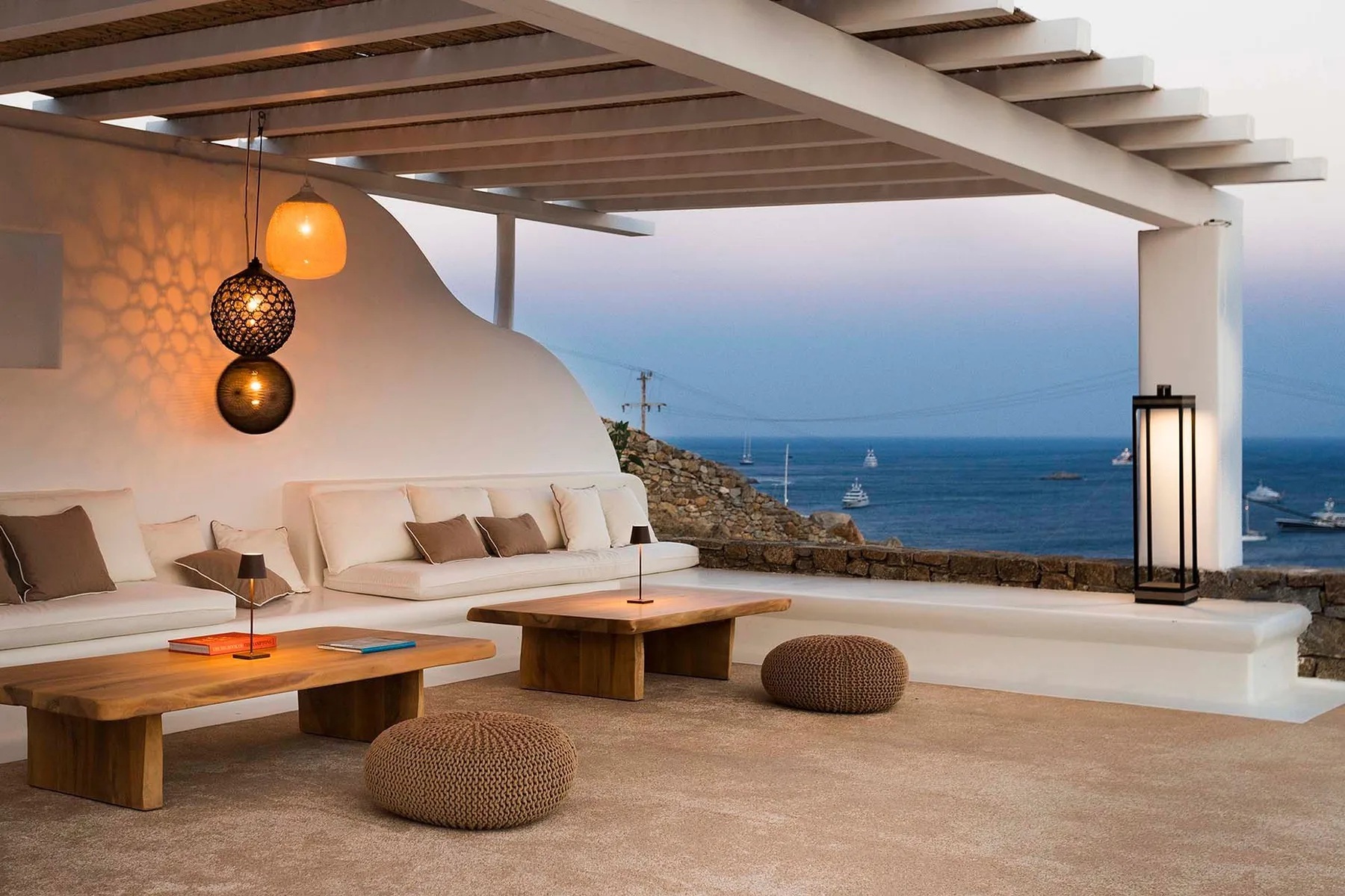 An open-air lounge with seating and a view of the sea.