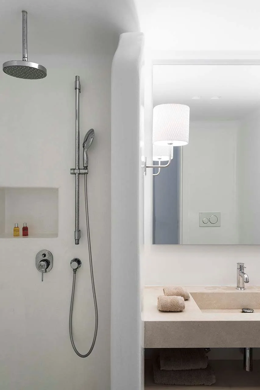 A bathroom with a walk-in shower beside a vanity and mirror.