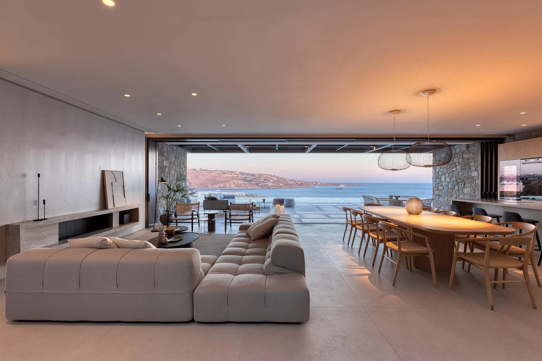 Una sala de estar y comedor modernos se abre a una vista del mar.