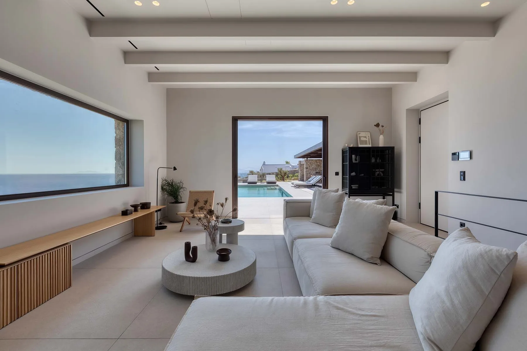 Una luminosa sala de estar da a una terraza, con una ventana amplia y una zona de asientos.
