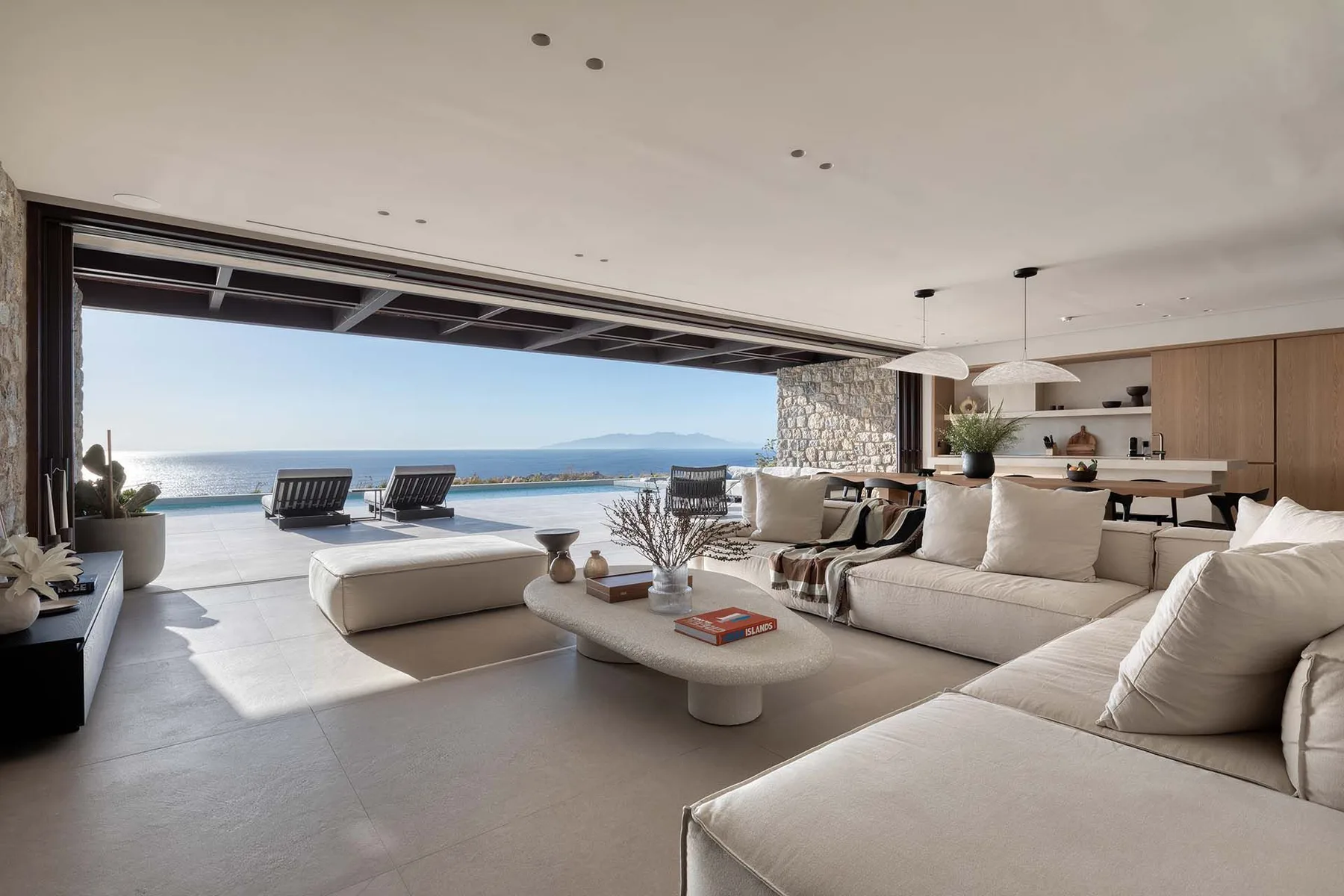 Una sala de estar moderna se abre a una terraza con vistas al mar.