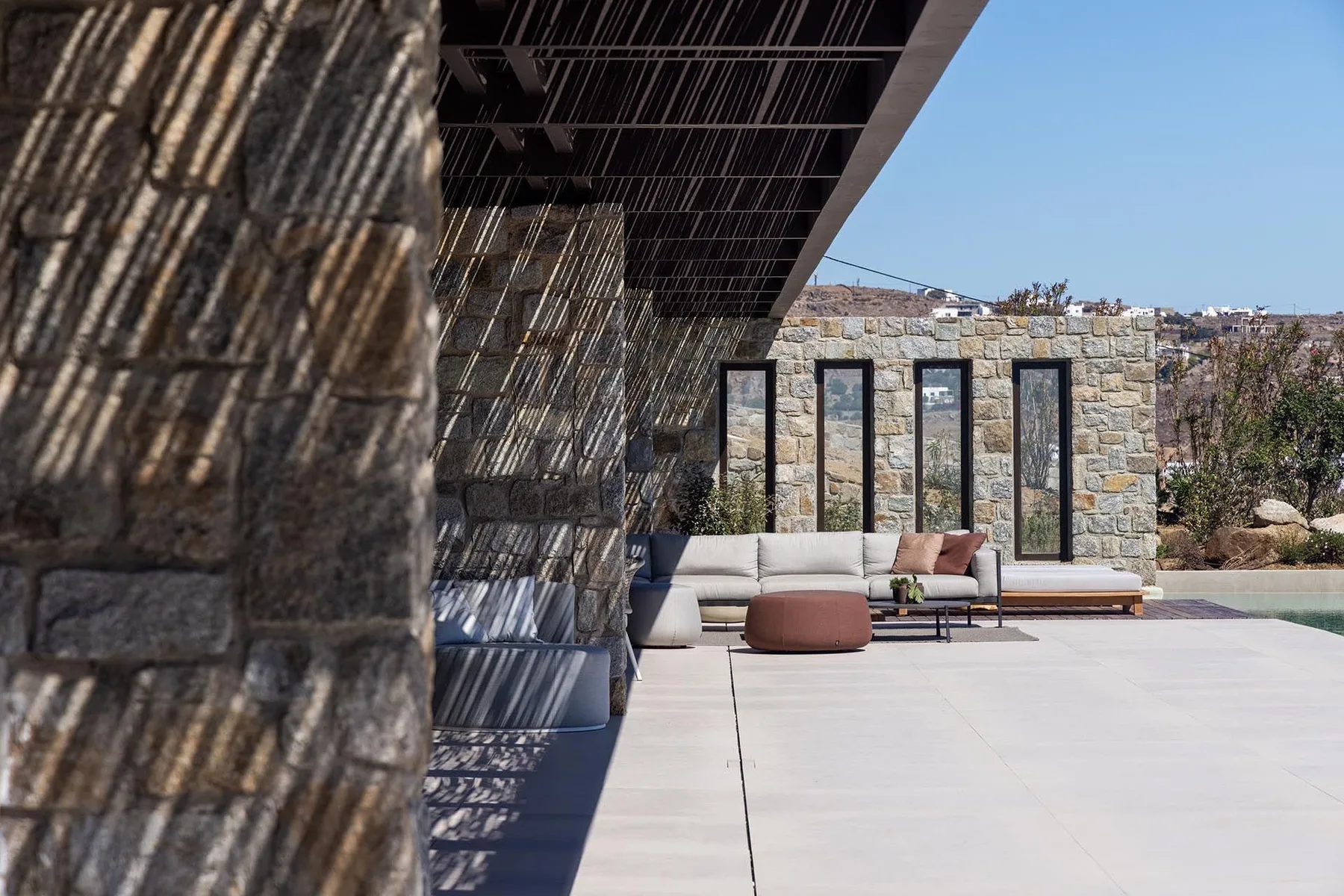 Un patio exterior con una zona baja para sentarse junto a un muro de piedra.