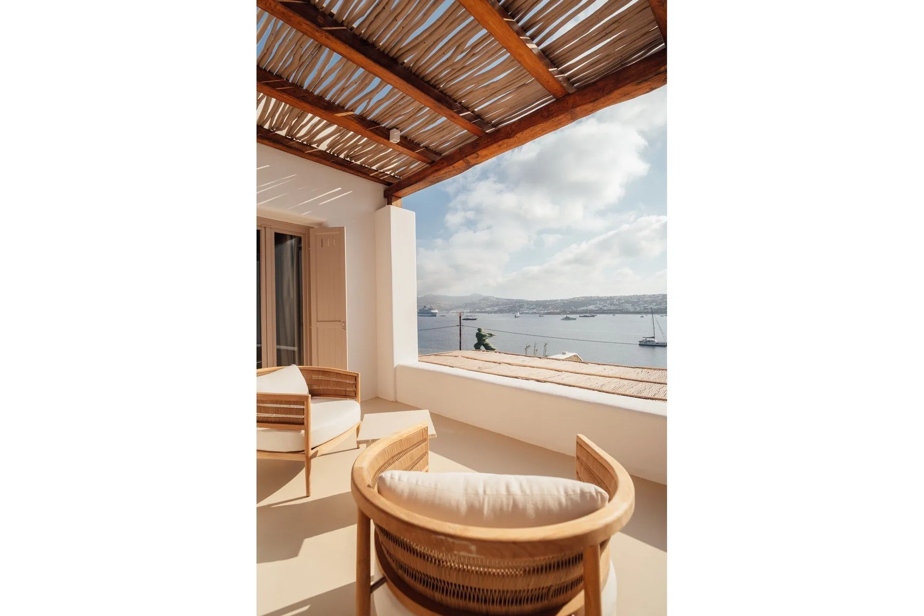 A covered terrace with curved seating overlooks the water.
