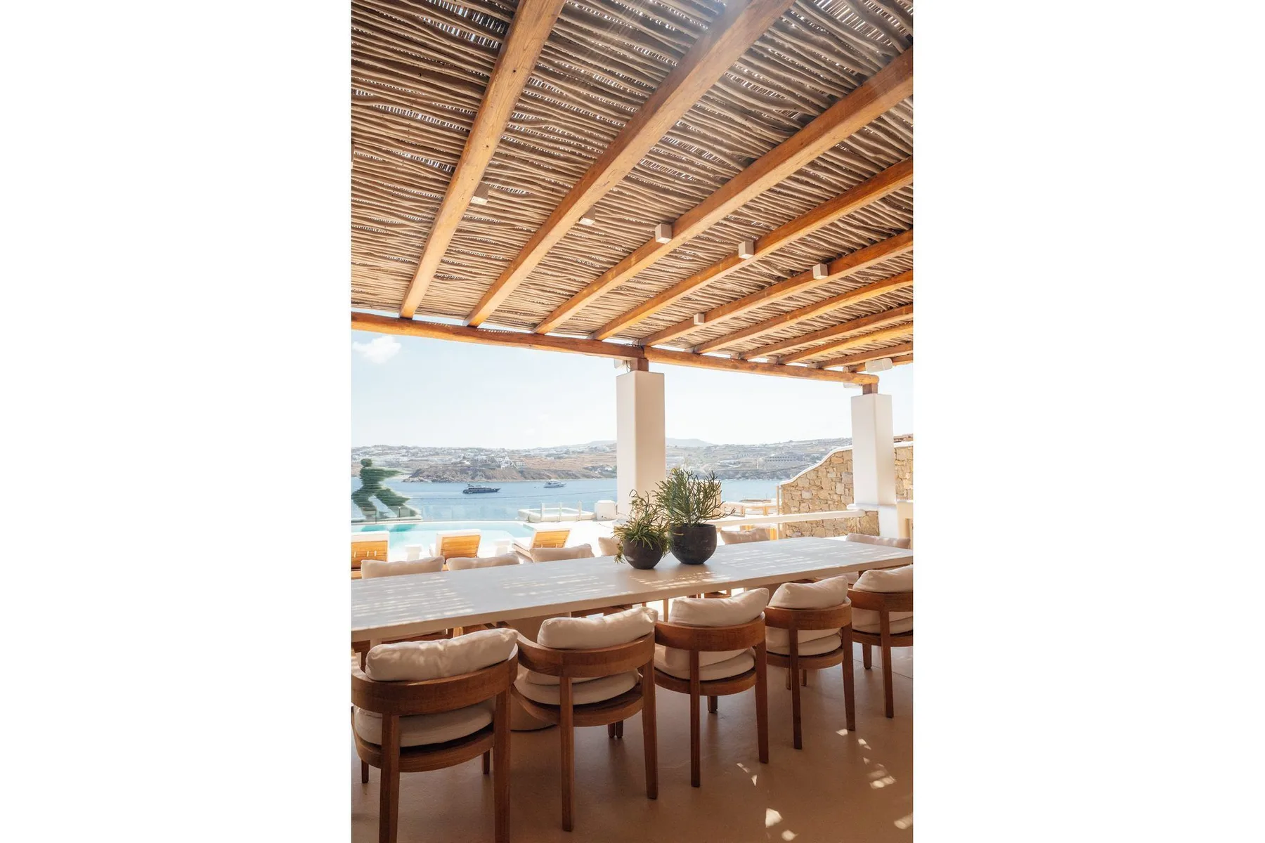 An open-air dining area with wooden seating overlooks the water.