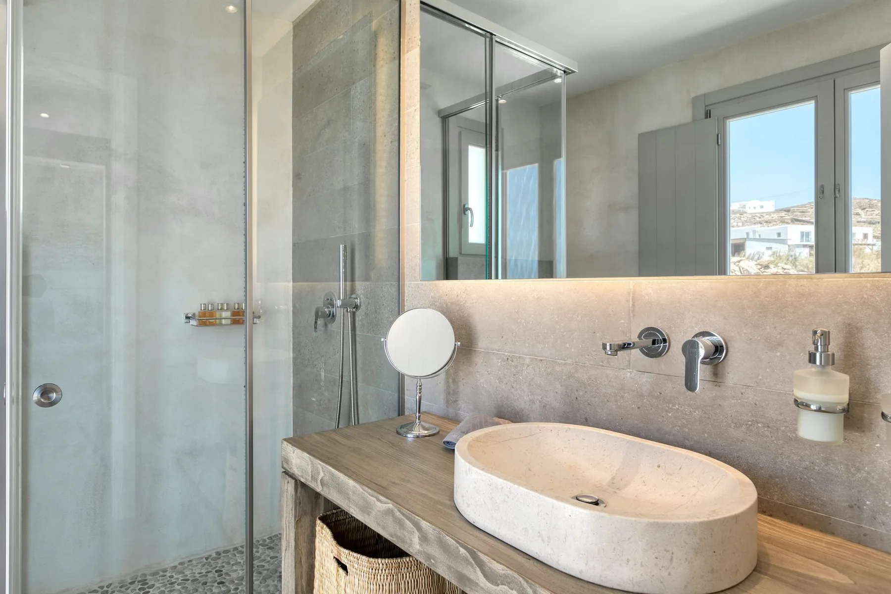 A modern bathroom with a large oval basin beneath a wall mirror.
