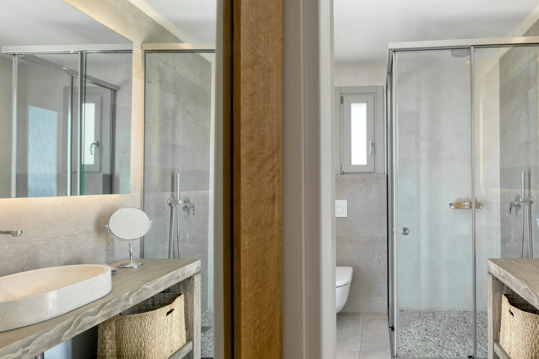 A bright bathroom with a glass shower and a vessel sink on a vanity.