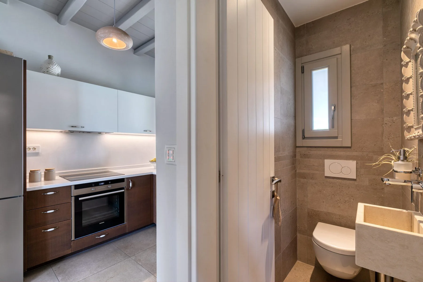A kitchen and bathroom are visible through an open doorway.