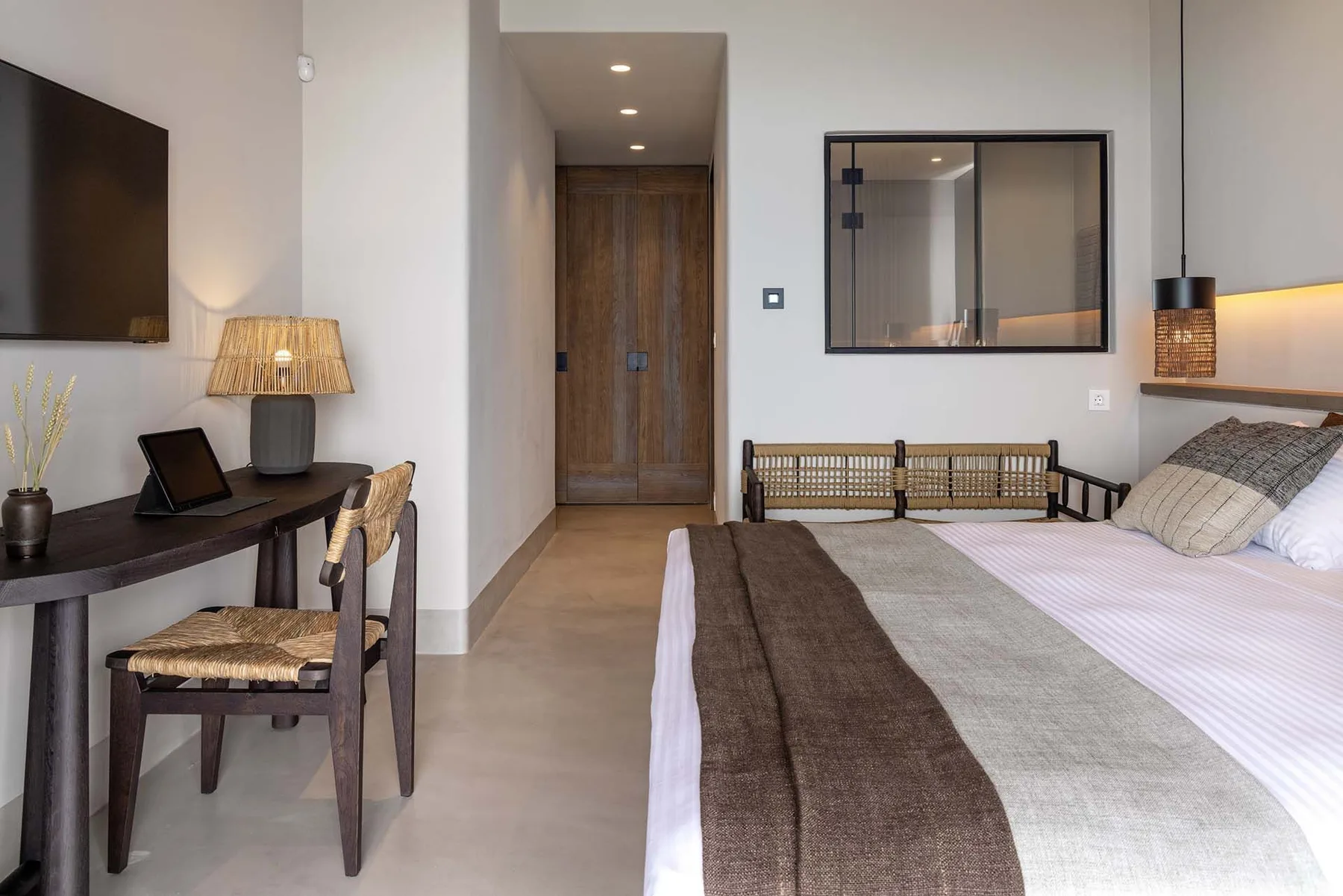 Un dormitorio con una cama, un escritorio y una puerta de madera.