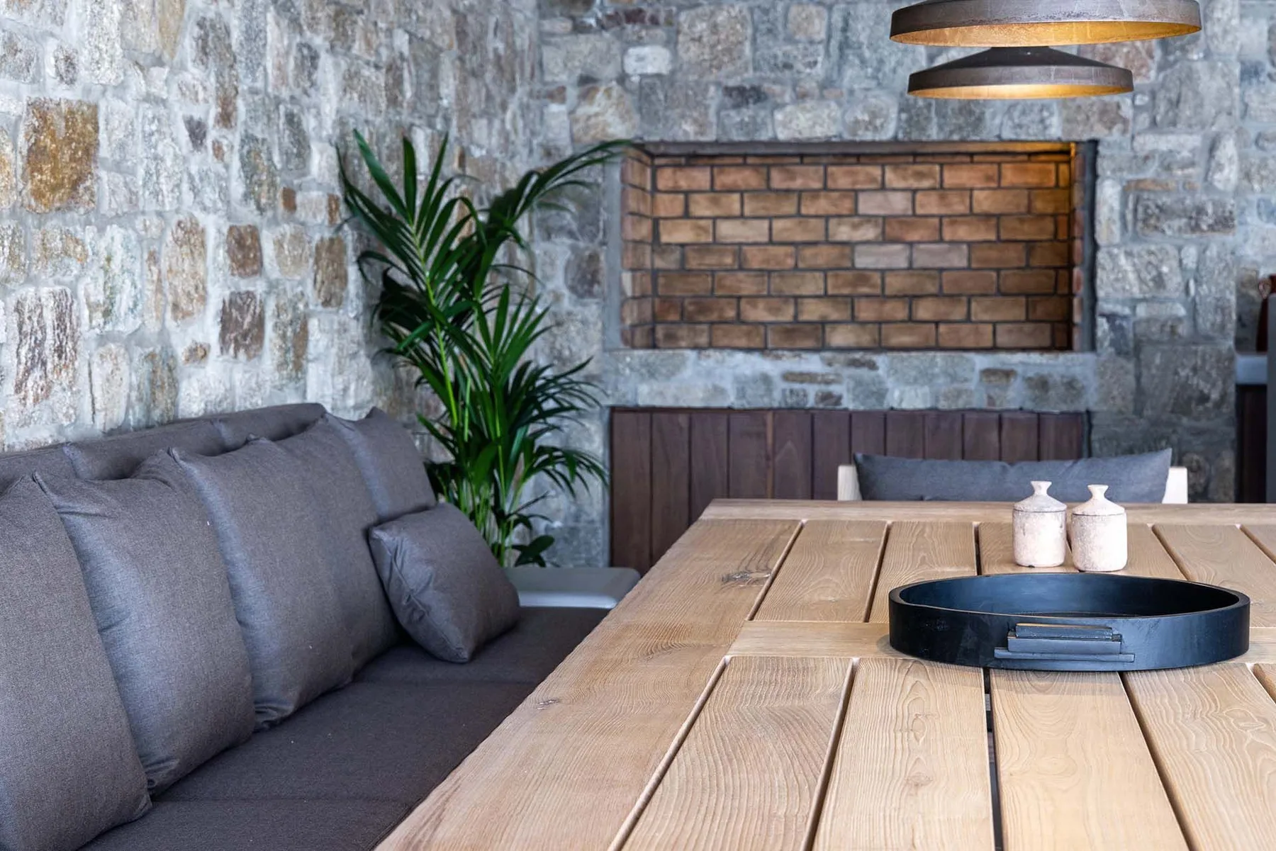 Una zona de estar con una mesa larga de madera y una planta en maceta.