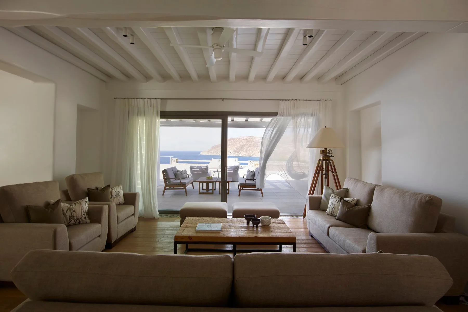 A living room with seating around a coffee table and sliding doors opening to a patio.