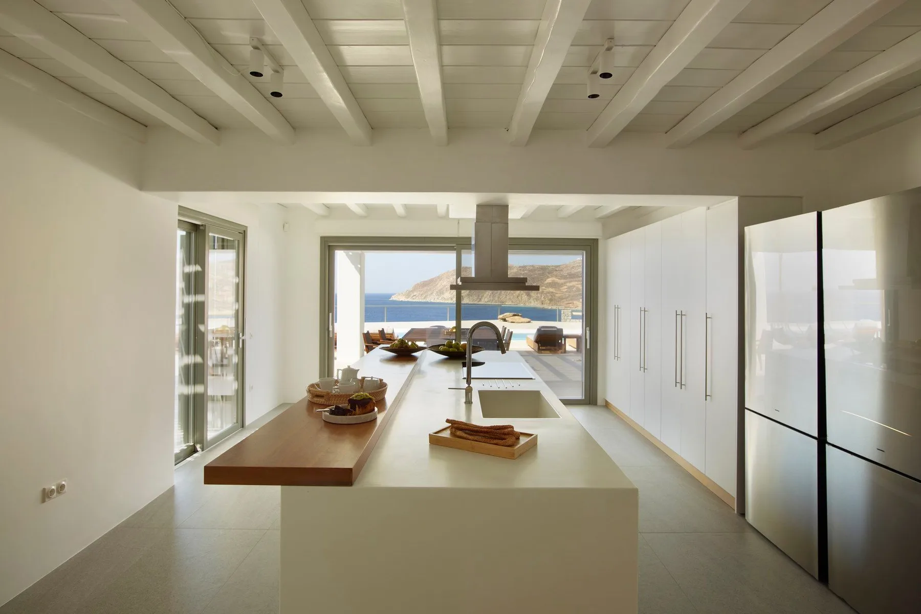 A bright kitchen with a large island and windows overlooking the water.