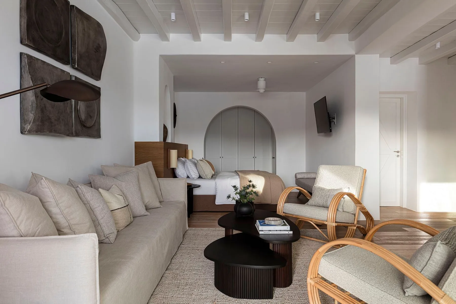 A bright living room with seating arranged around low coffee tables.