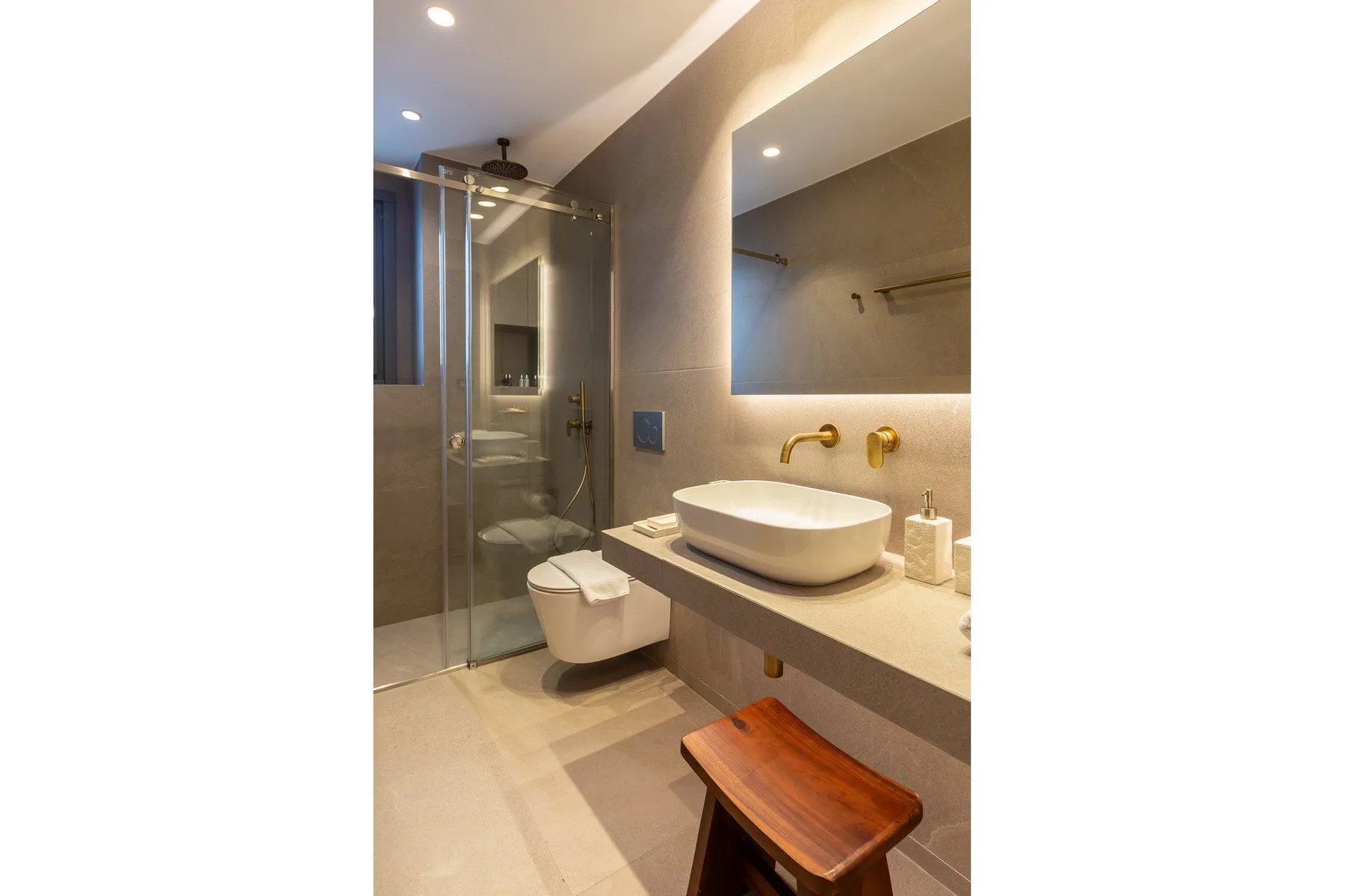 A modern bathroom with a sink and a glass shower.