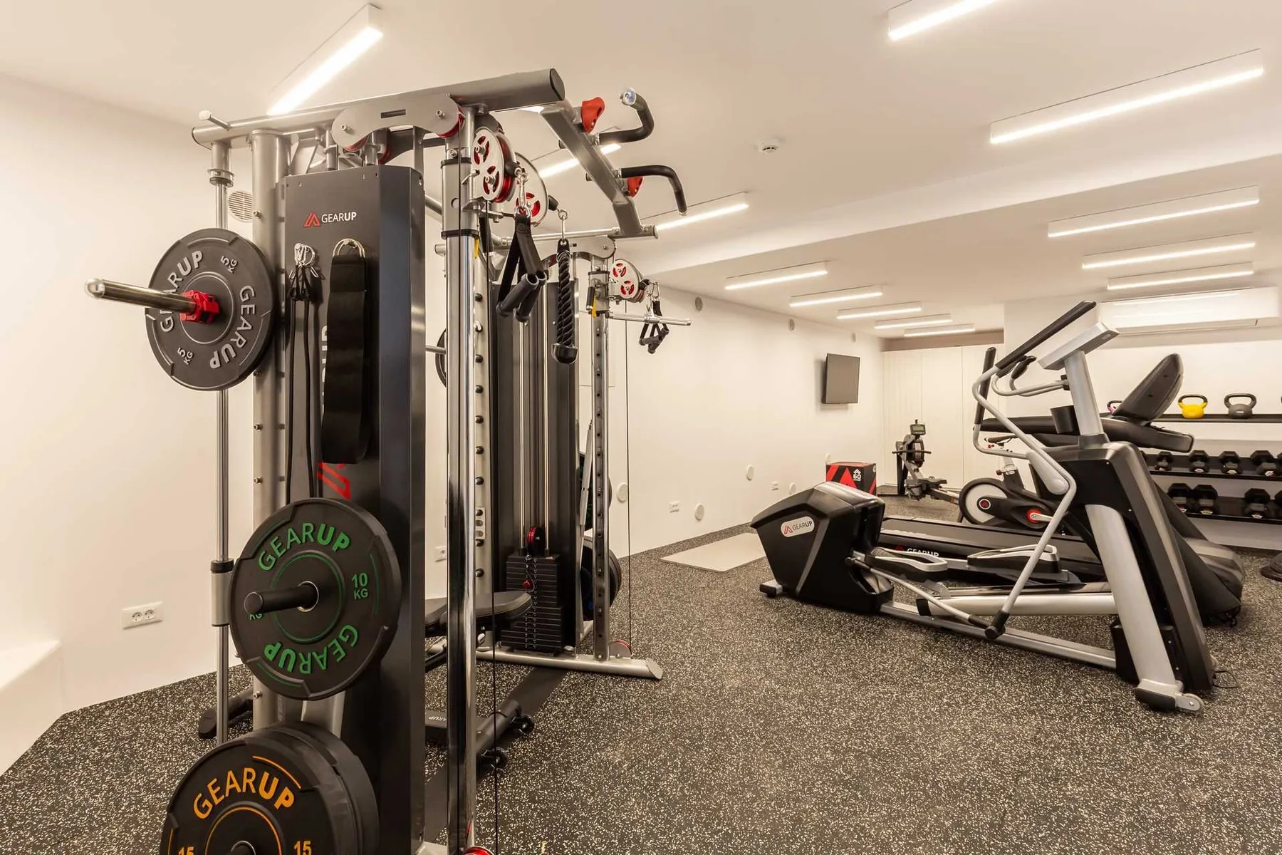 A gym with weight-training equipment and cardio machines.