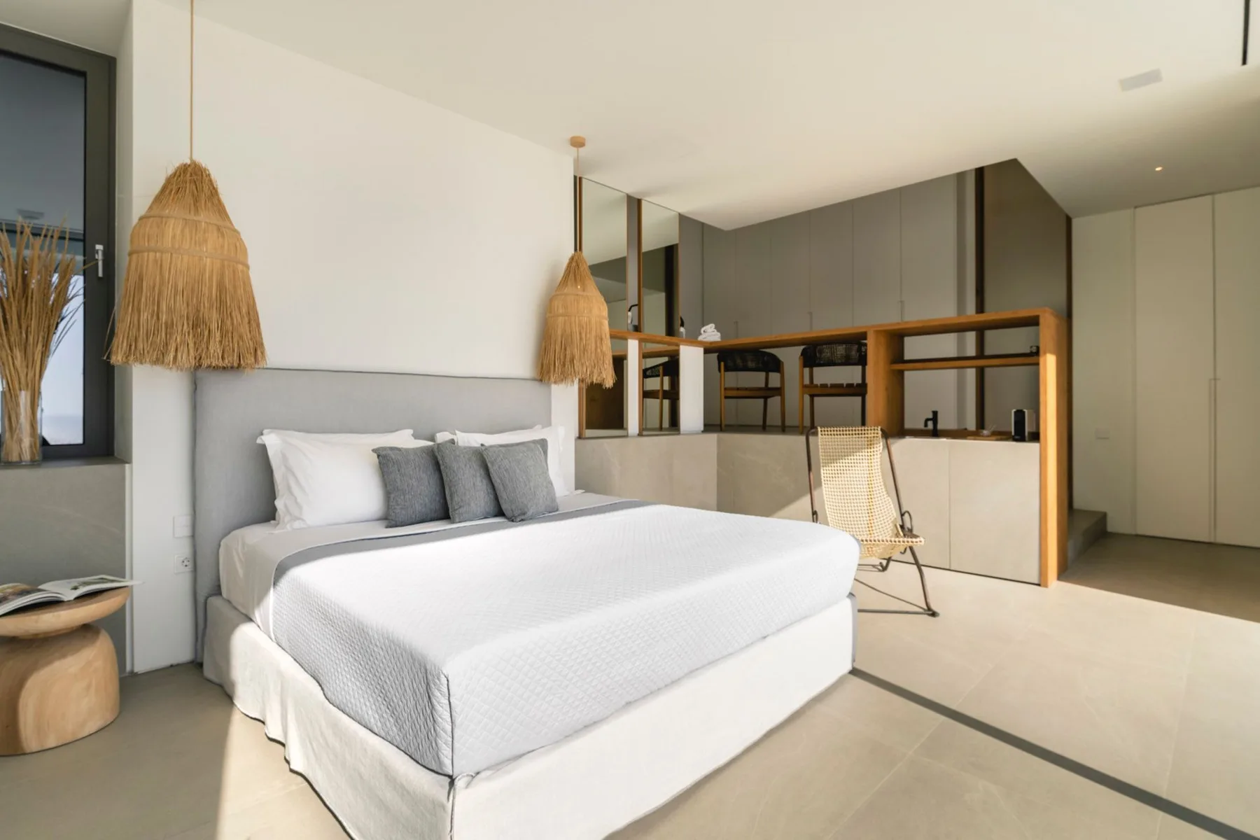 A bright bedroom with a neatly made bed and a wooden divider.