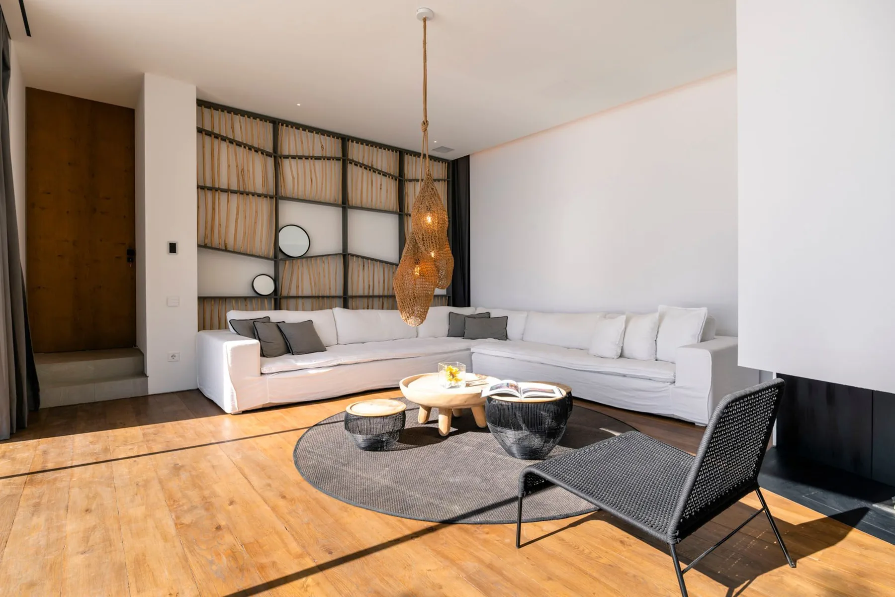 A bright living room with white seating around a low table and rug.