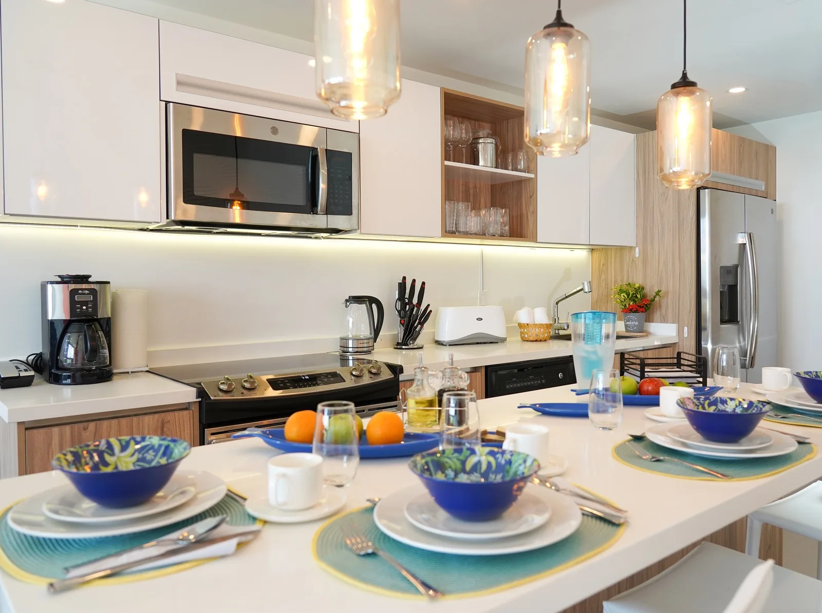 A bright kitchen with a central island set for a meal.