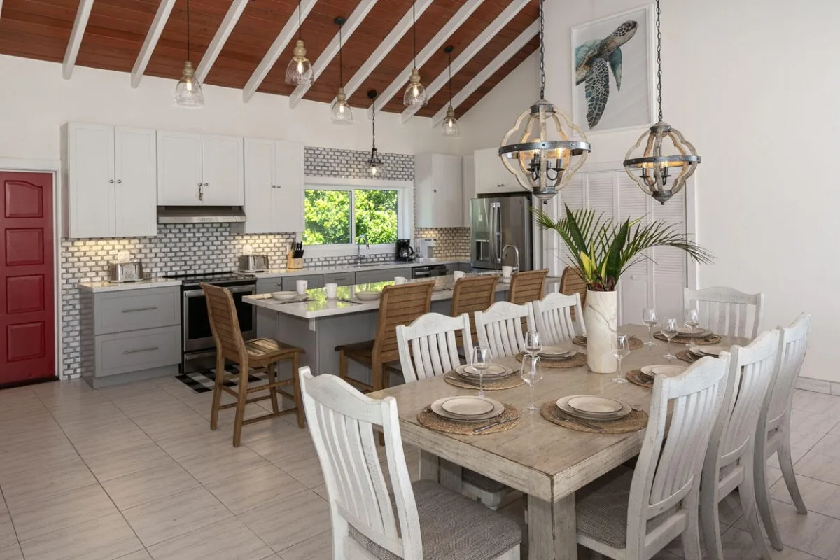 Un comedor con la mesa puesta está junto a una cocina abierta.