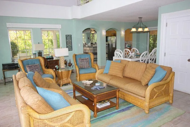 A living room with wicker seating, blue cushions, and a coffee table.