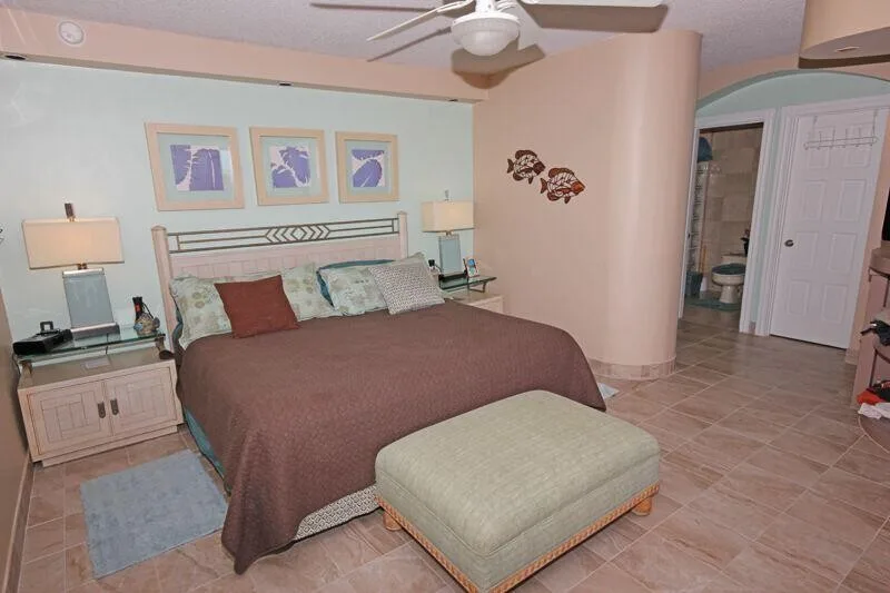 A bedroom with a bed, bedside tables, and a cushioned bench.