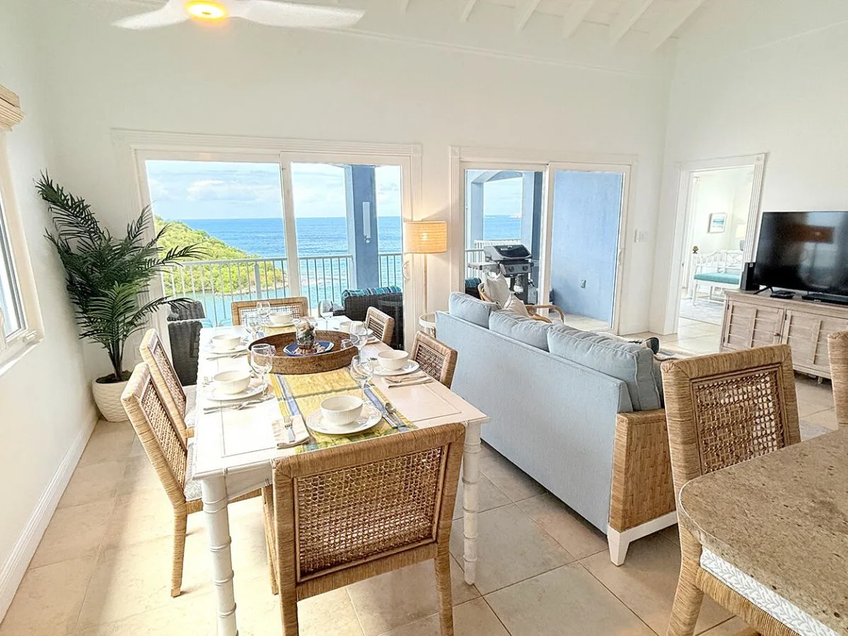 Una luminosa sala de estar y comedor se abre a un balcón con vistas al mar.