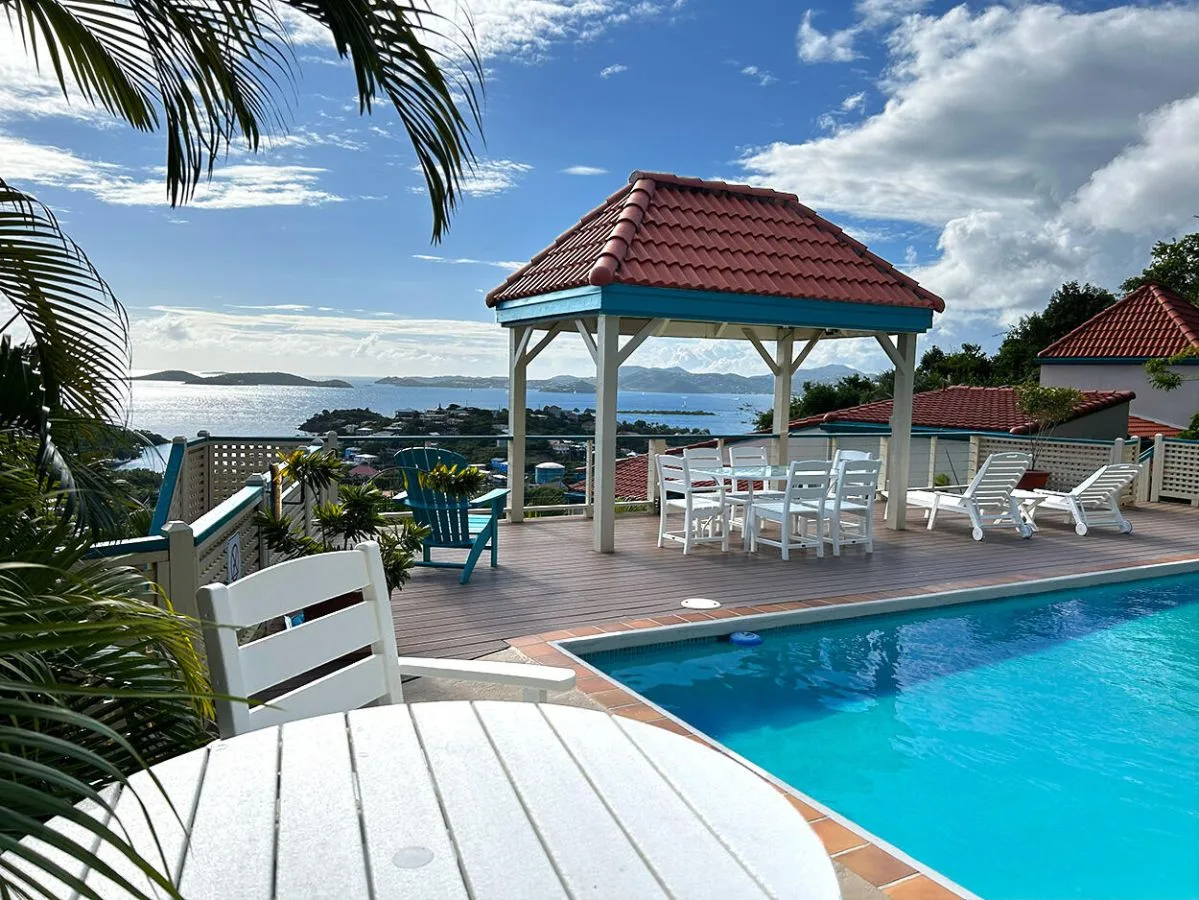Zona común: Un patio junto a la piscina tiene una zona de estar cubierta y vistas al agua.