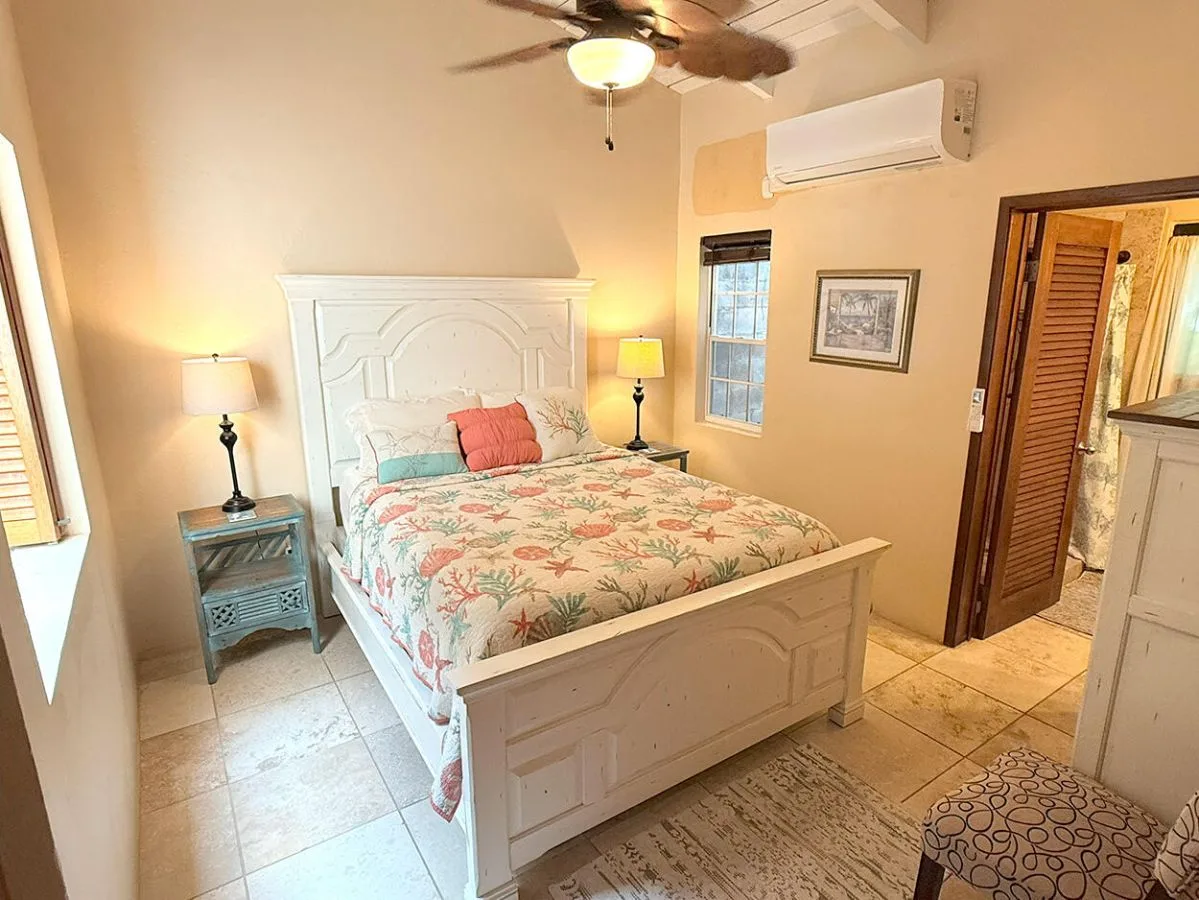 Un dormitorio con una cama cubierta con ropa de cama floral y lámparas de noche.