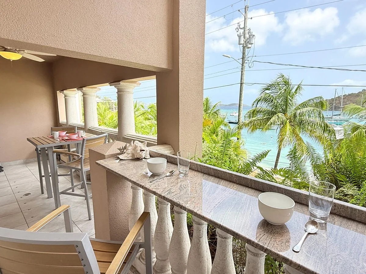 Un comedor cubierto tiene vistas a palmeras y al agua.