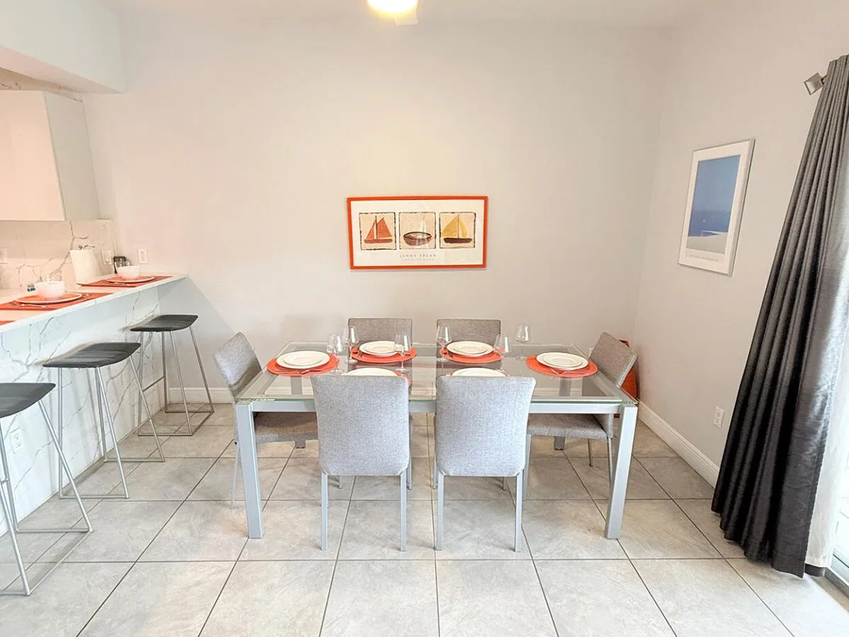 Un comedor con una mesa puesta con platos y sillas.