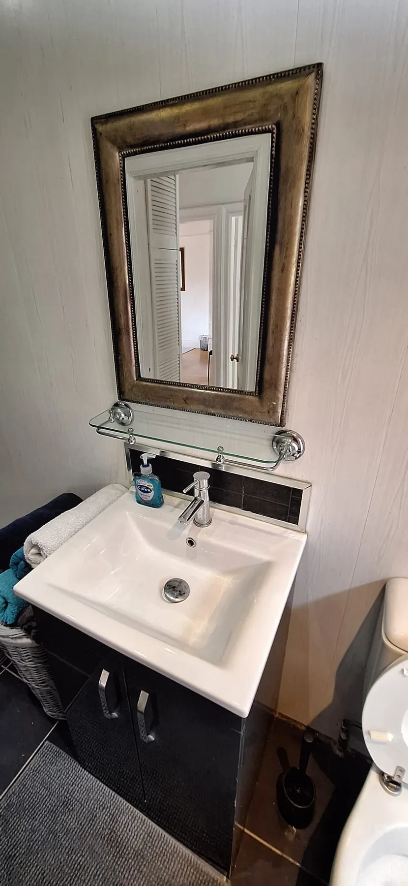 A bathroom vanity with a sink and a framed mirror above it.