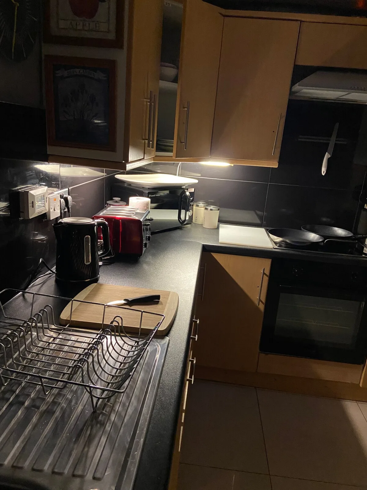 A kitchen with a countertop, sink, and cooking appliances.