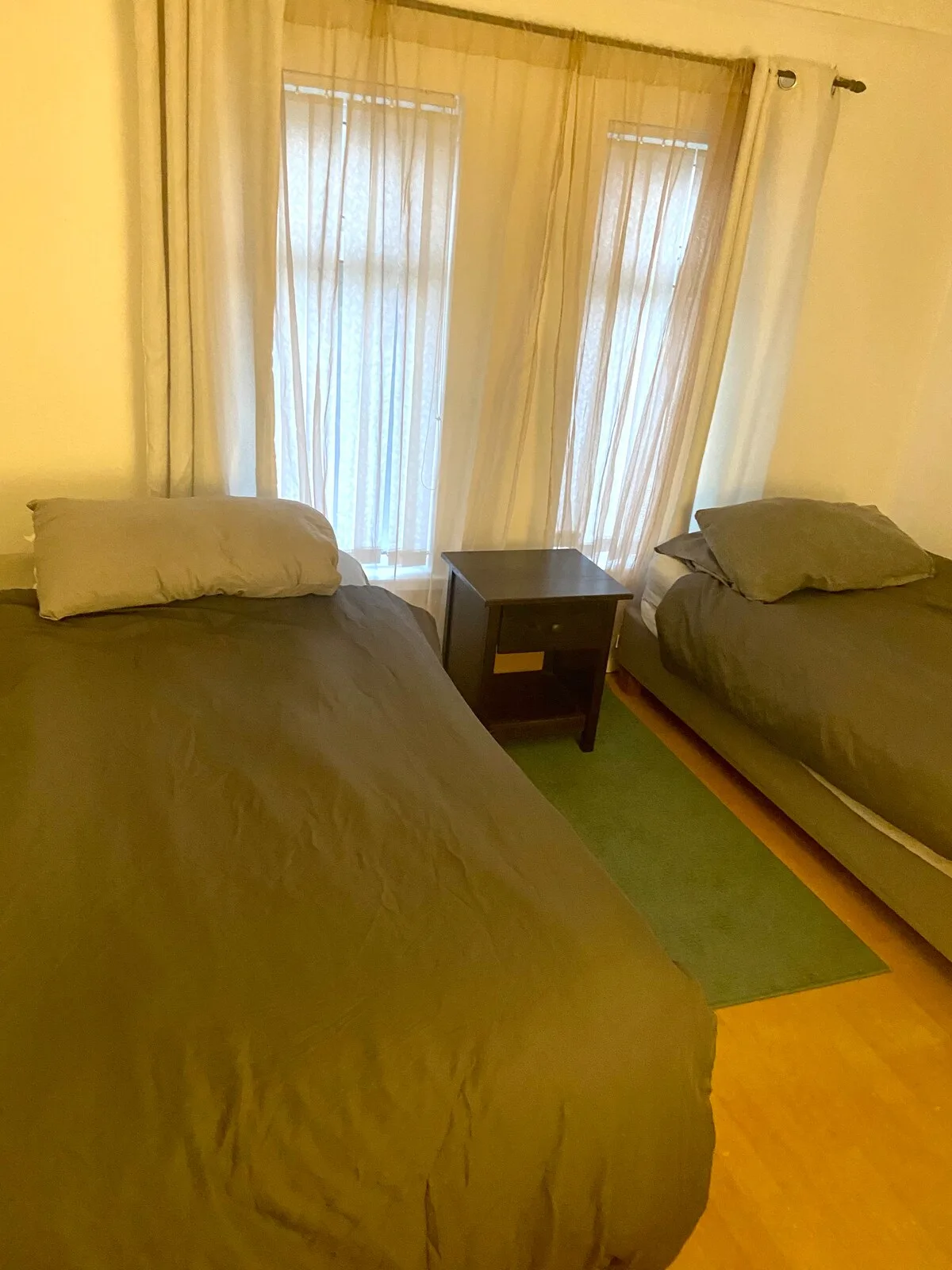 A bedroom with two beds and a small table between them.