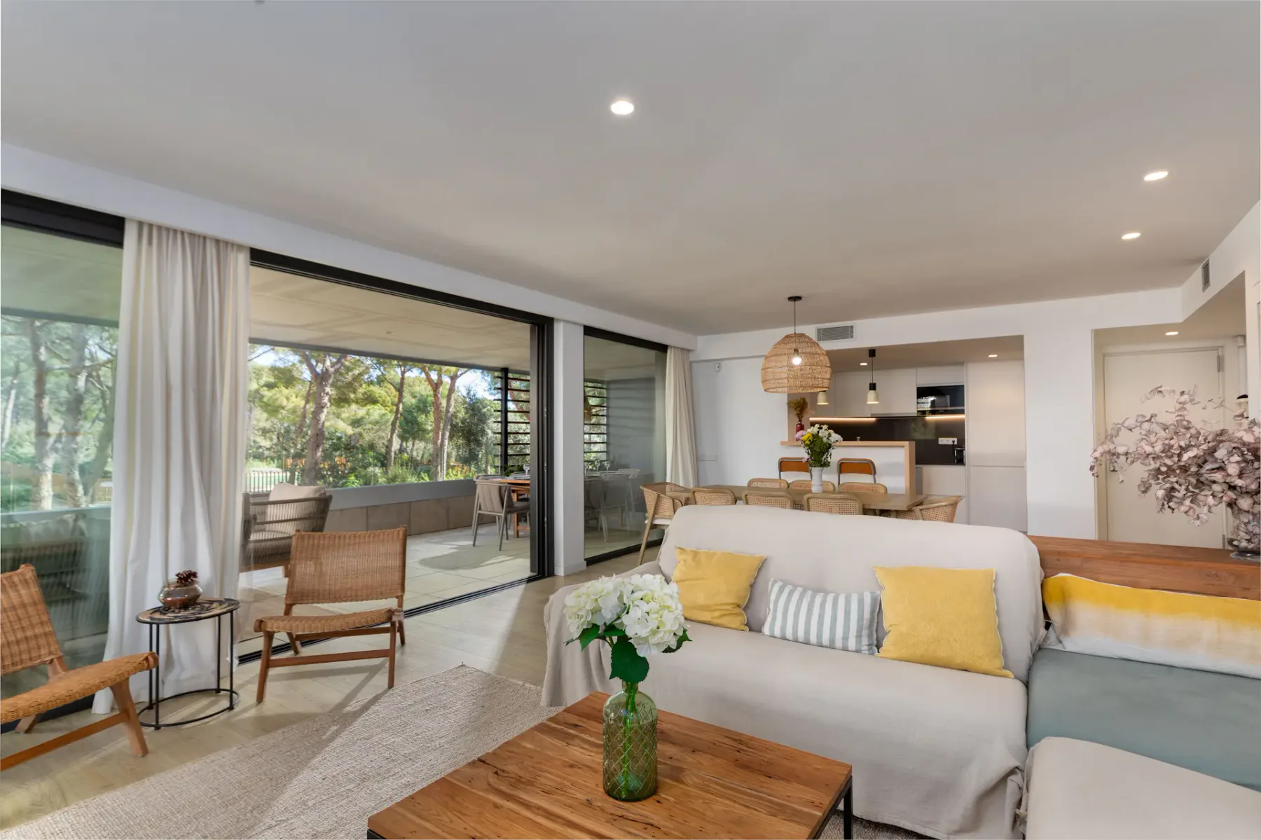 A bright living room opens onto a patio through wide glass doors.