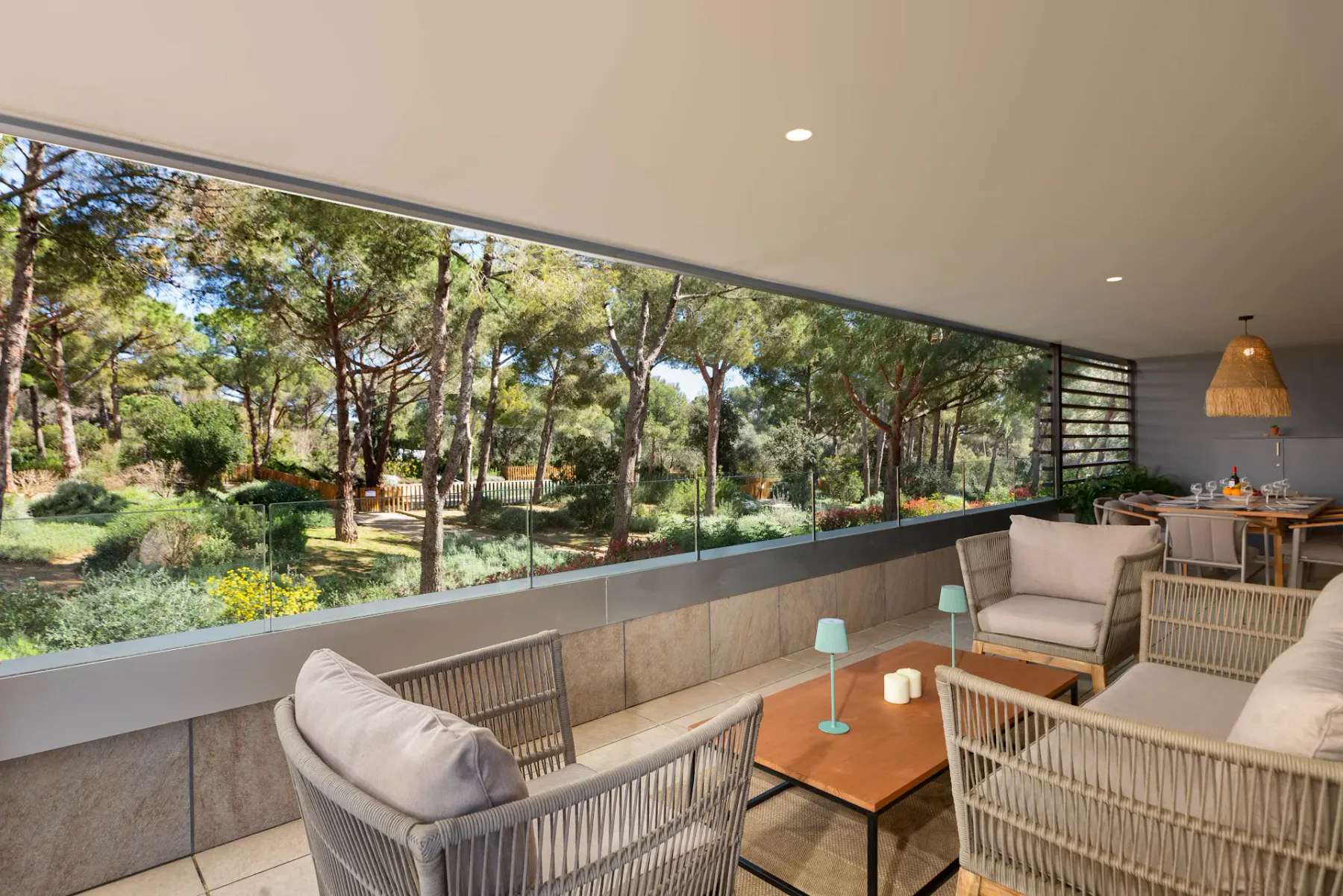 A lounge seating area faces a wide window overlooking a leafy garden.