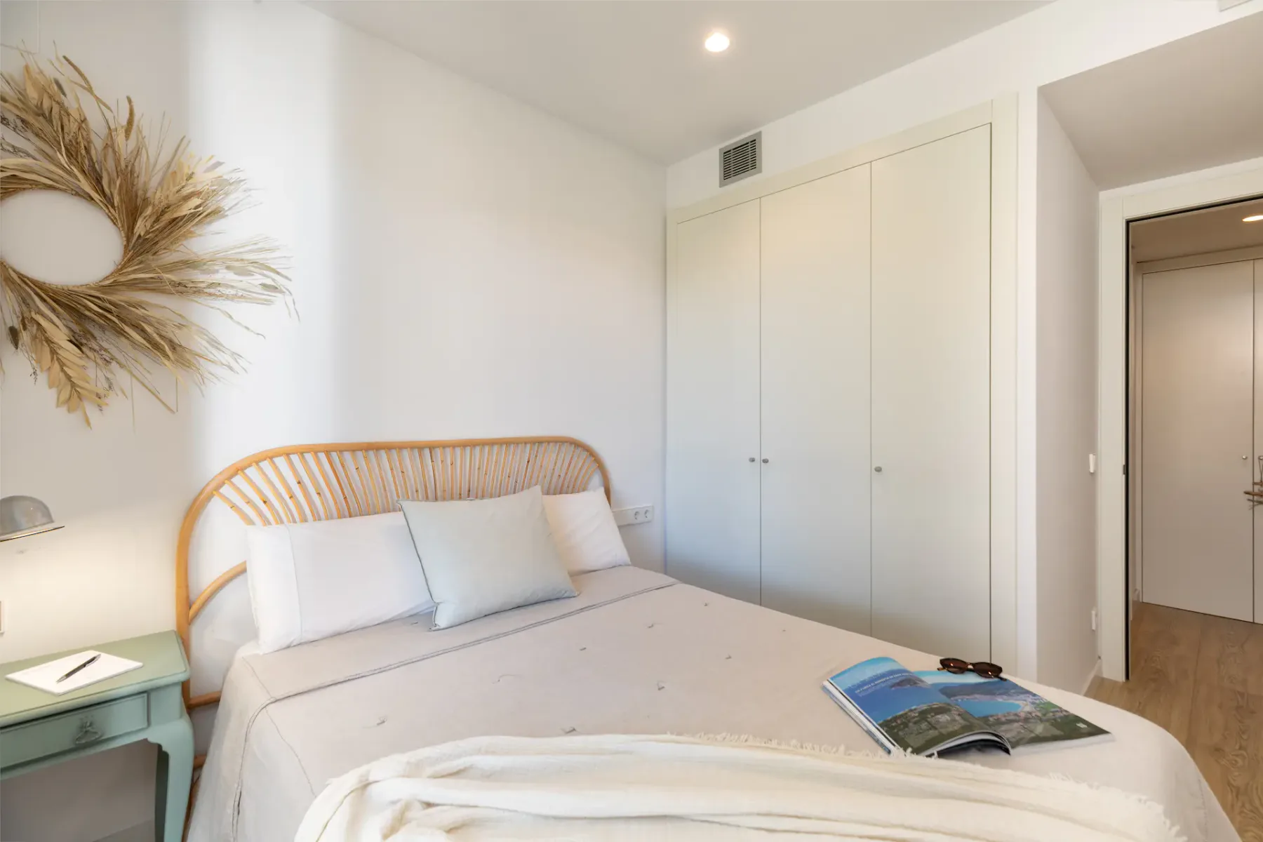 A bright bedroom with a bed and a large built-in closet.