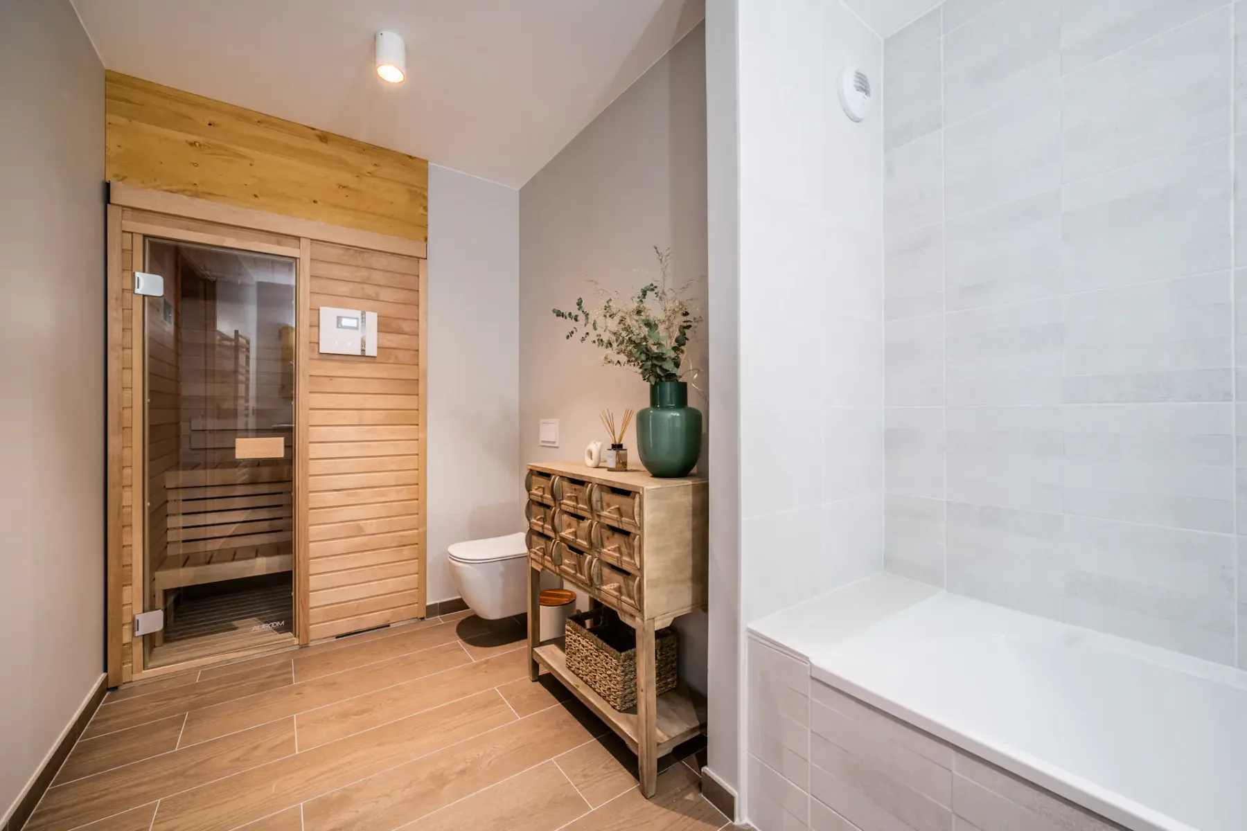 Un baño con una sauna de madera, bañera e inodoro.