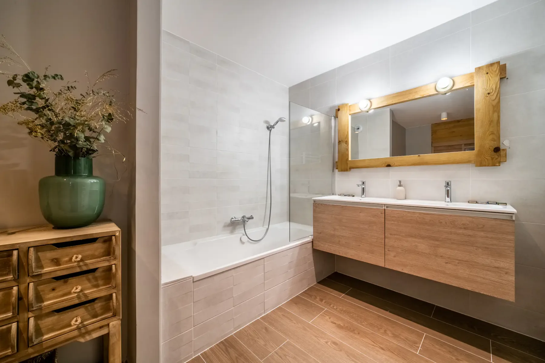 Un baño moderno con bañera, ducha y mueble de lavabo de madera.
