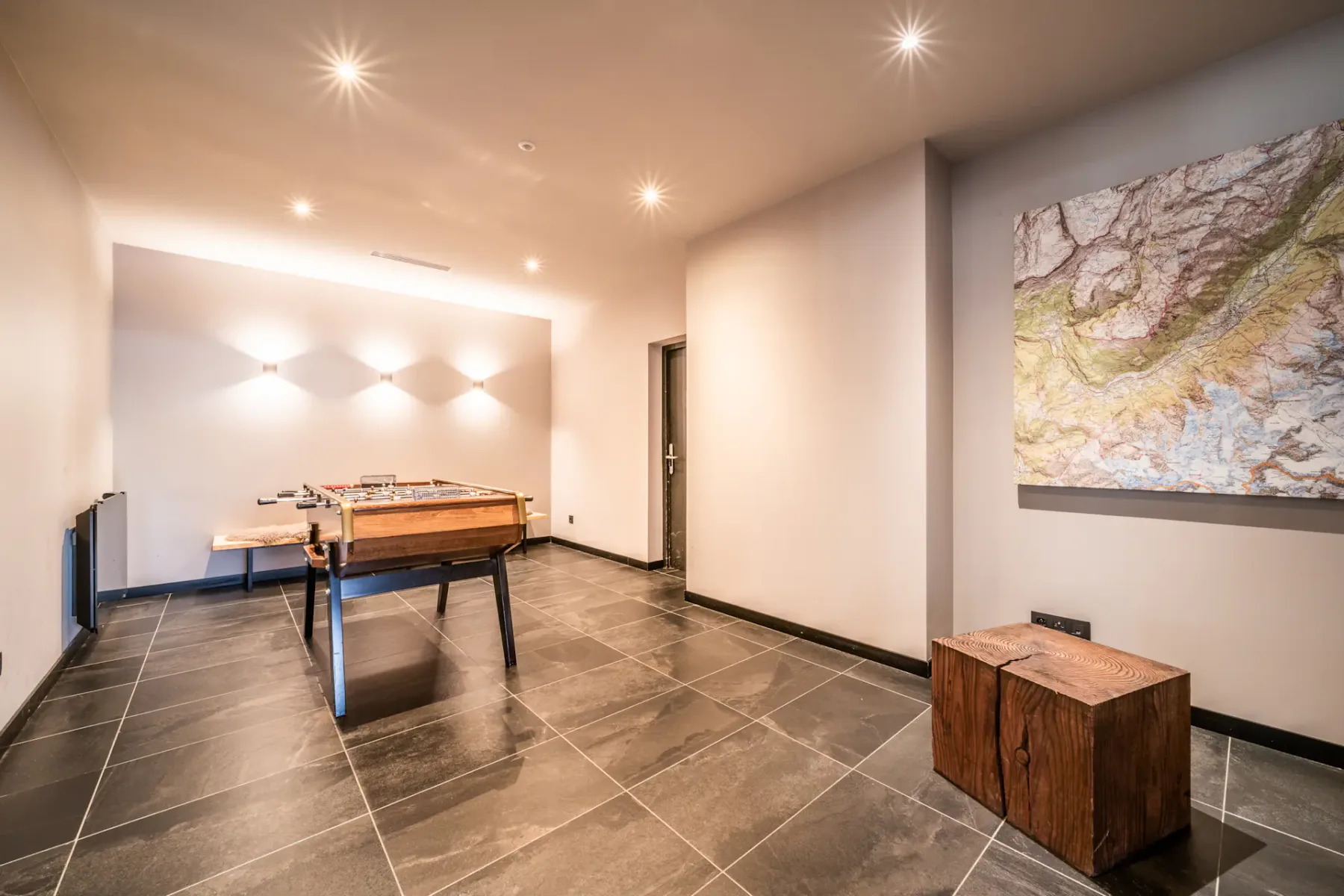 Una luminosa sala de juegos con una mesa de billar y un gran mapa en la pared.