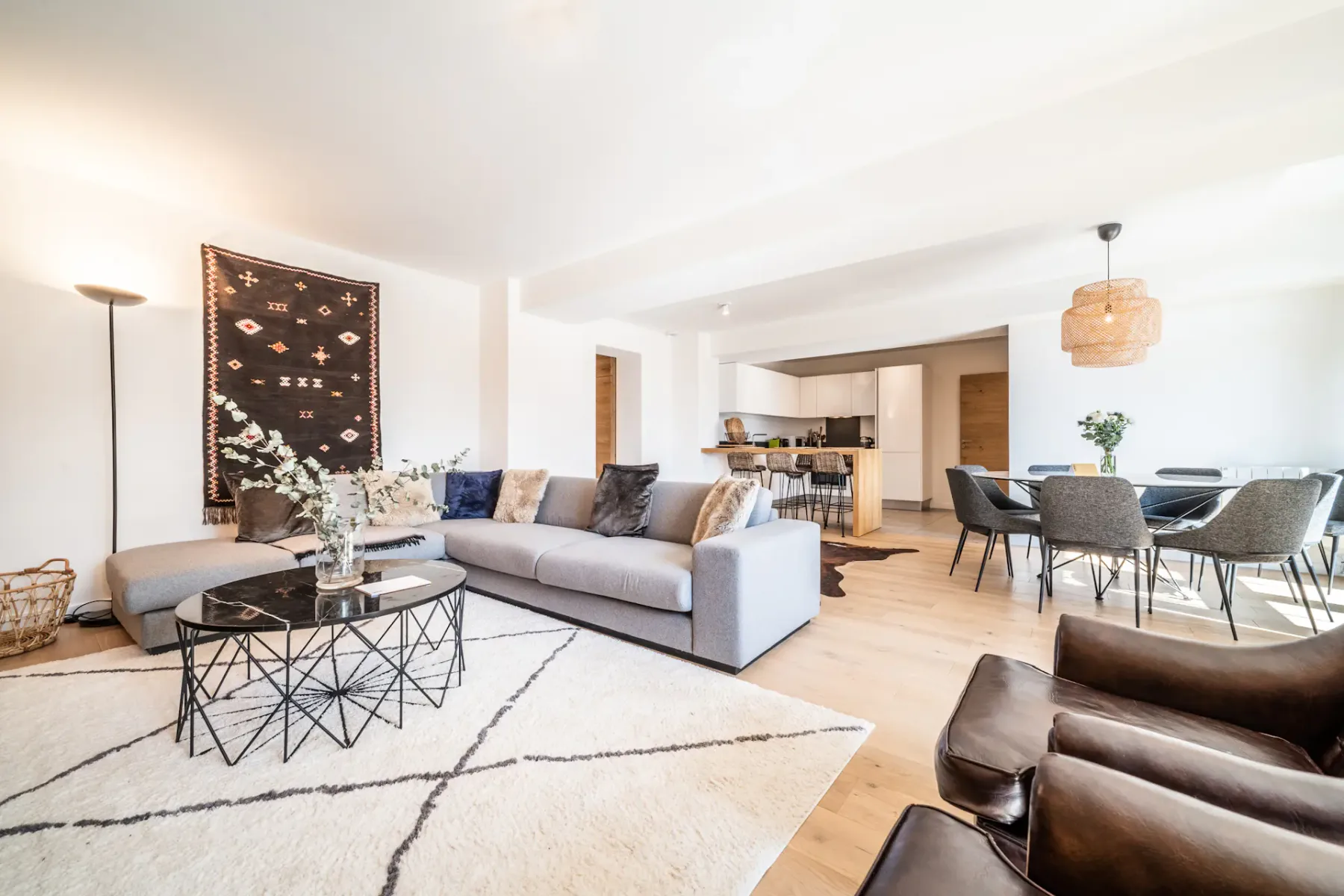 Una luminosa sala-comedor de planta abierta con un sofá seccional y una mesa de comedor.