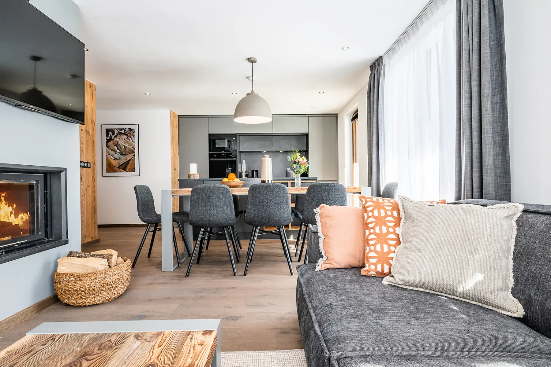 Una luminosa sala-comedor de planta abierta, con asientos y una cocina al fondo.